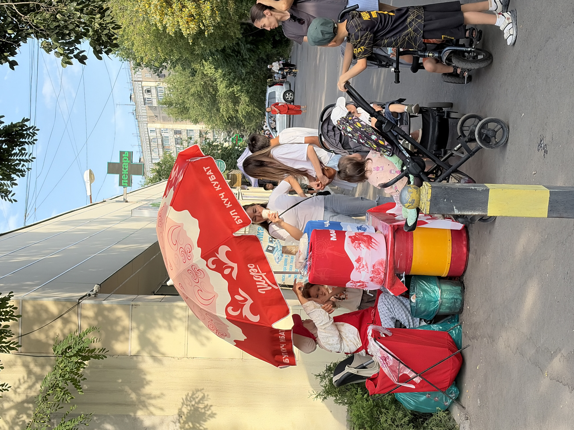 Street vendors, cyclists, and park visitors during midday hours