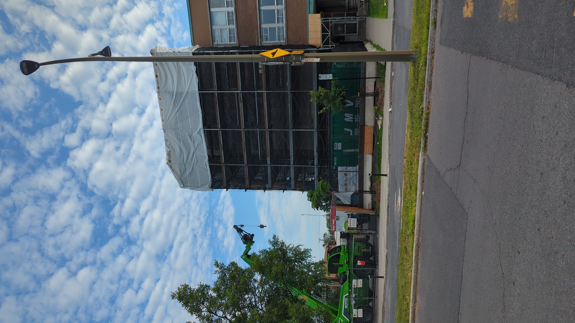 Construction site and blooming trumpet flowers in summer Montreal