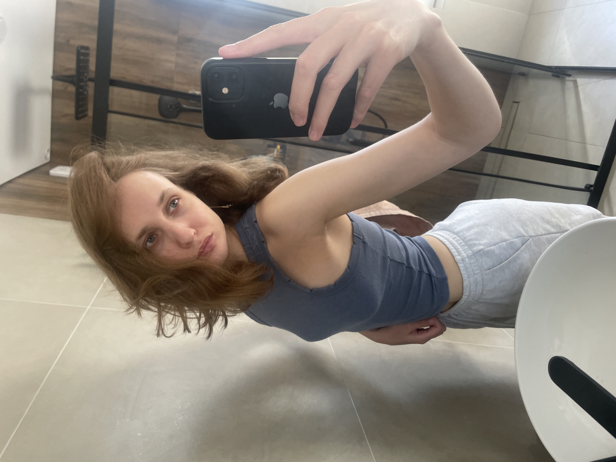 Woman takes morning selfies in Russian bathroom, holds perfume