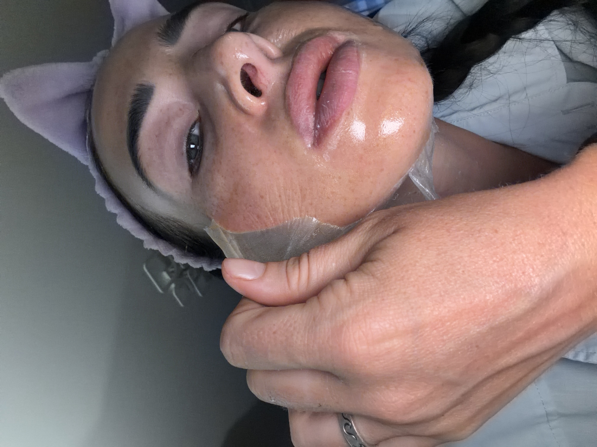 Peel-off face mask mid-removal, skincare routine close-up