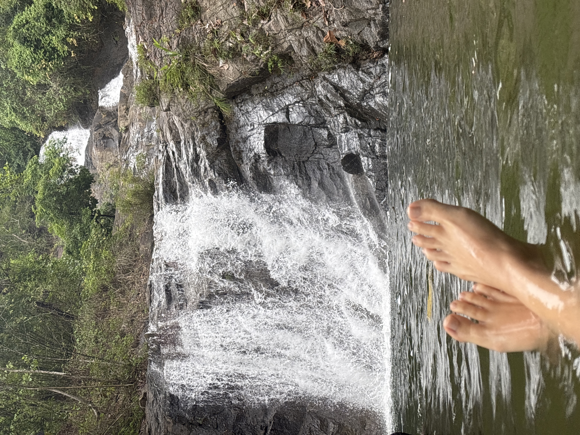 Swimmers enjoy waterfall pool in Thai Mueang, Thailand