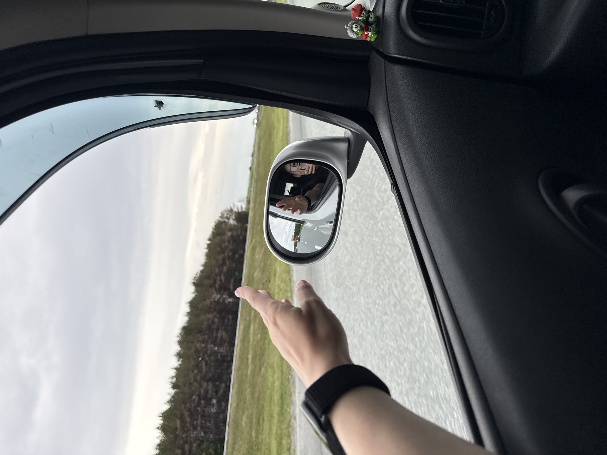 Person waves from car window in Russkie Kirmeni, Russia