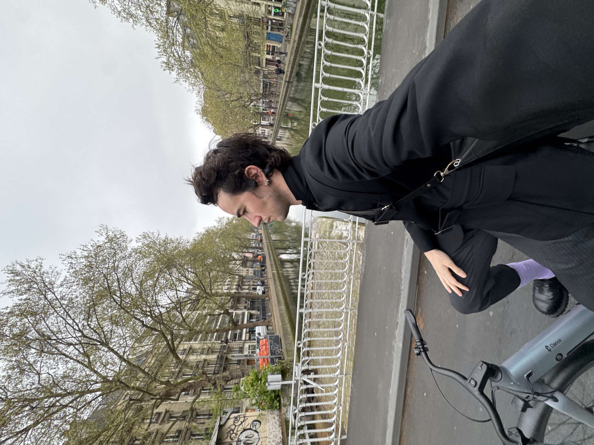 Cyclist pauses on Paris bridge during morning hours