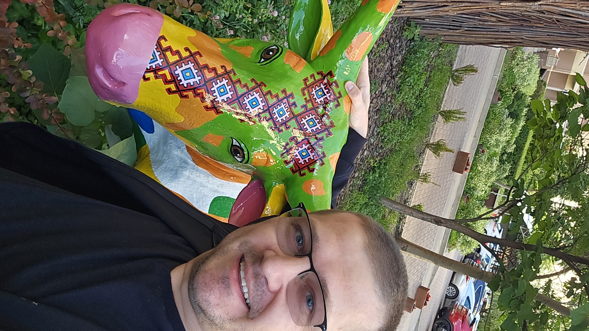Selfie with painted cow sculpture and flower planters in Kyiv