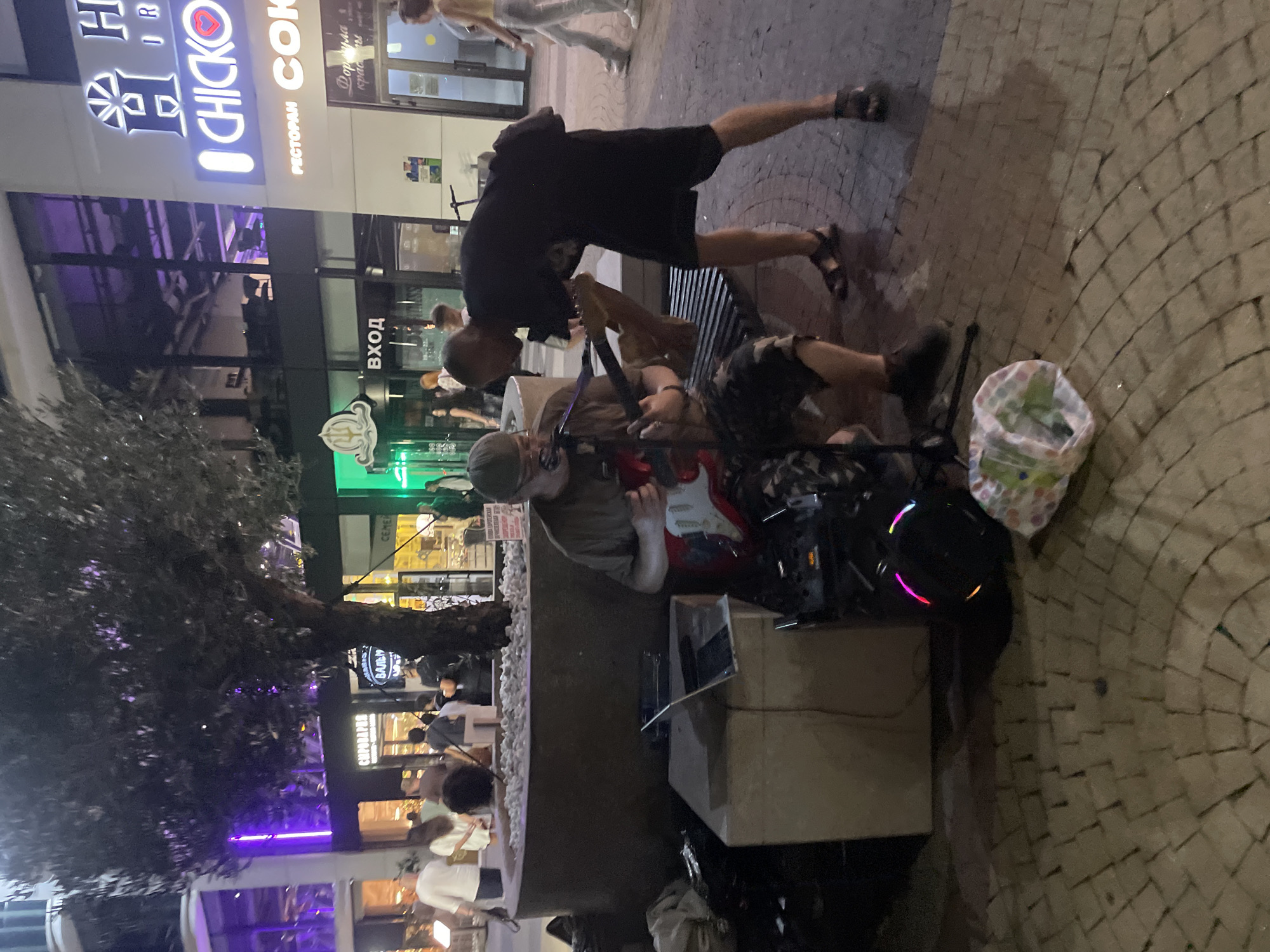 Late-night electric guitar session outside a Sadovyi building complex