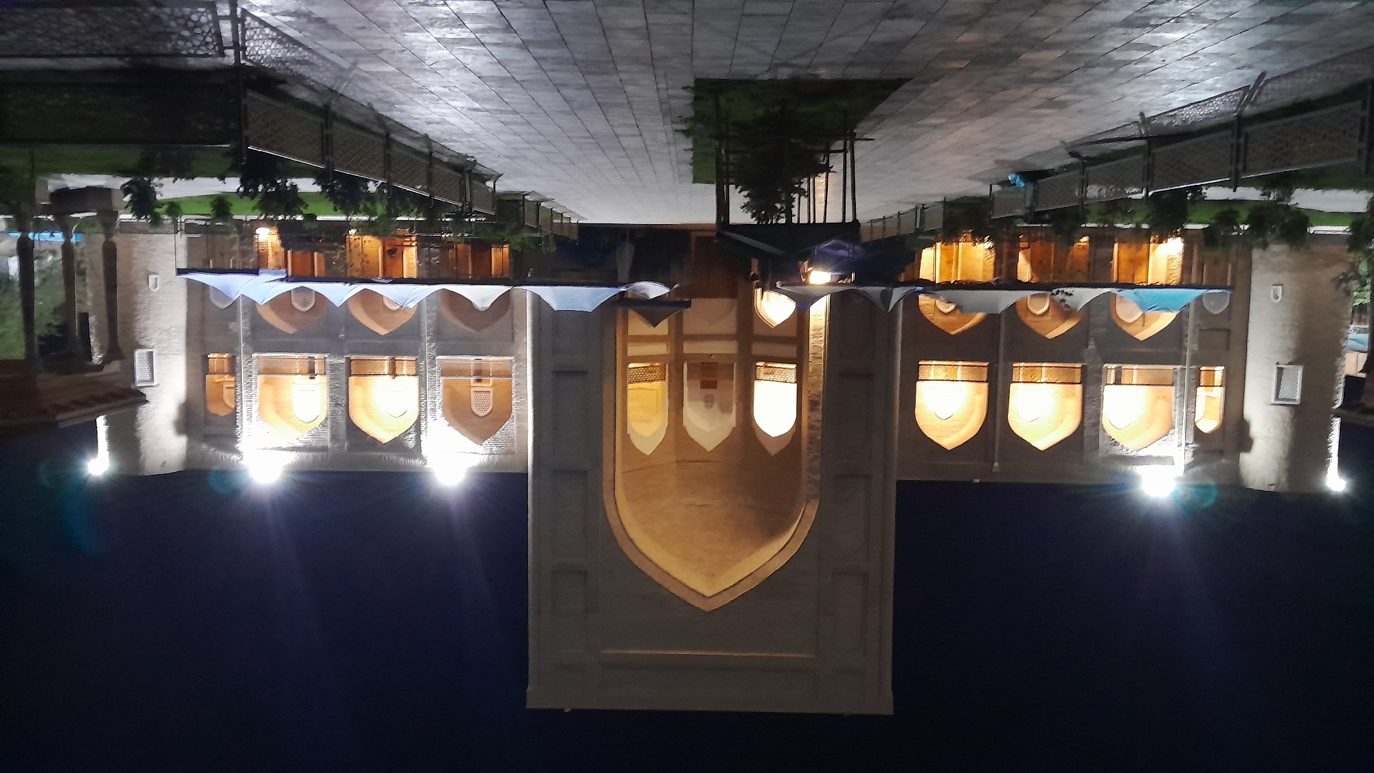 Illuminated ornate landmark photographed at night in Denov