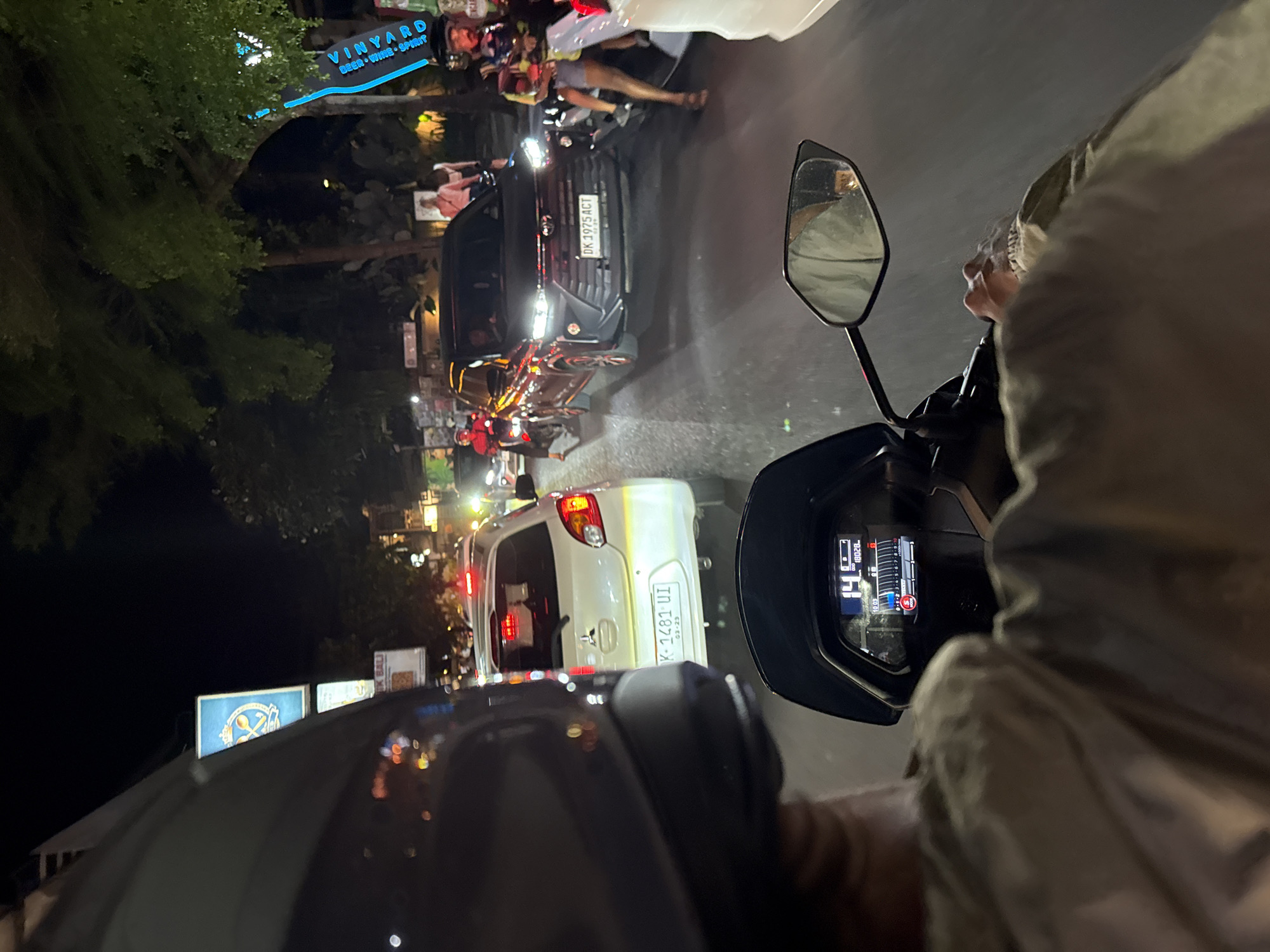 Motorcyclist navigates dense nighttime traffic in Ubud District