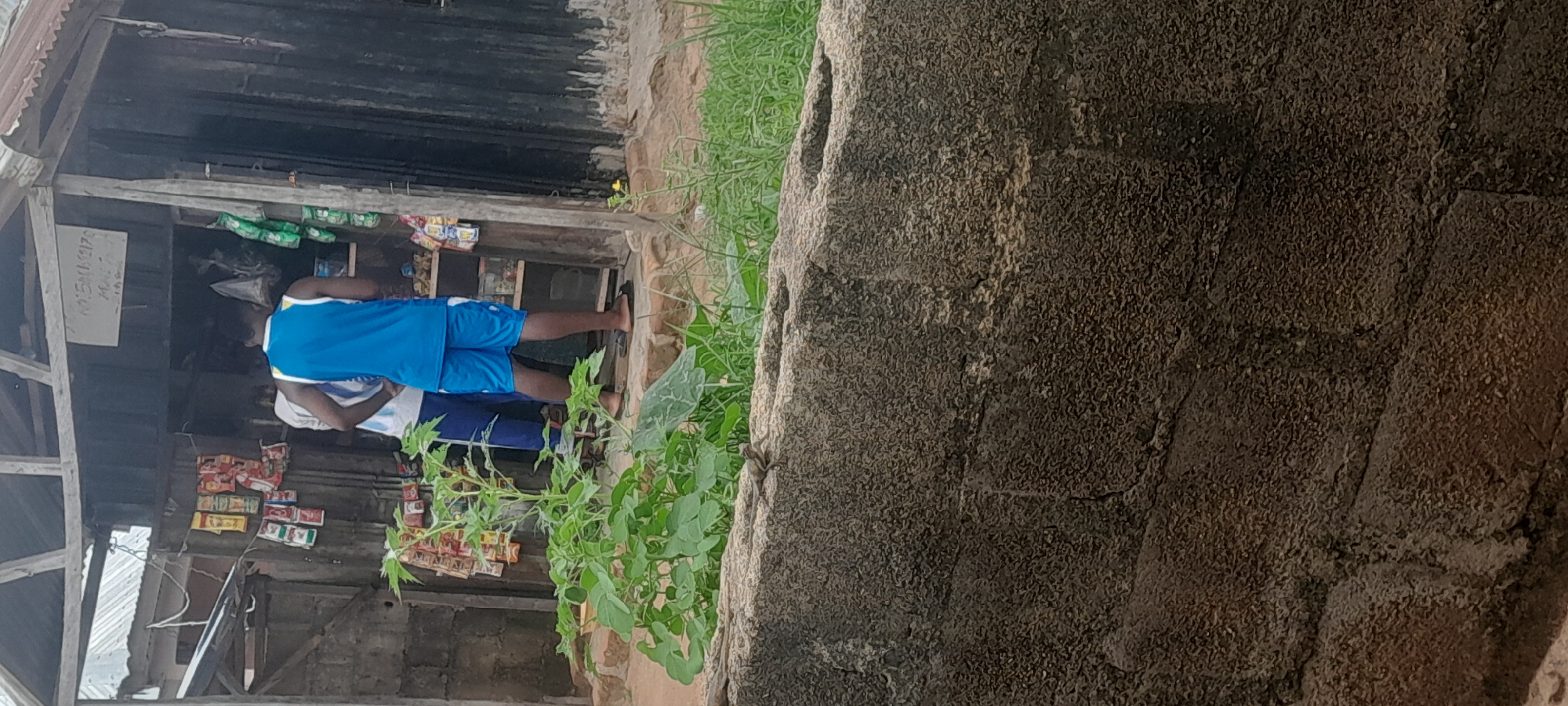 Roadside stall, a brick wall, and two Pidgin memes