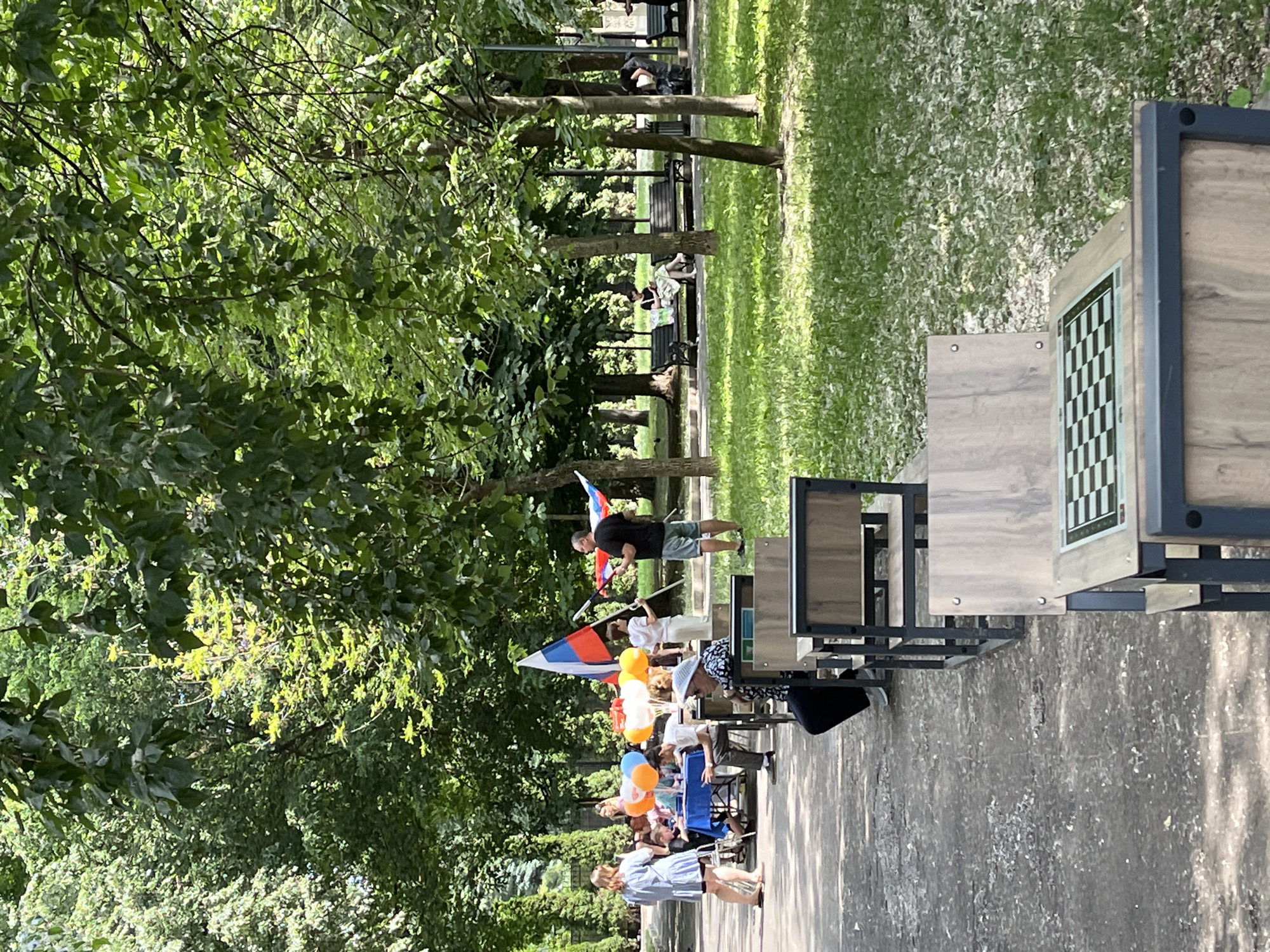 Park gathering features stage performance and chess games