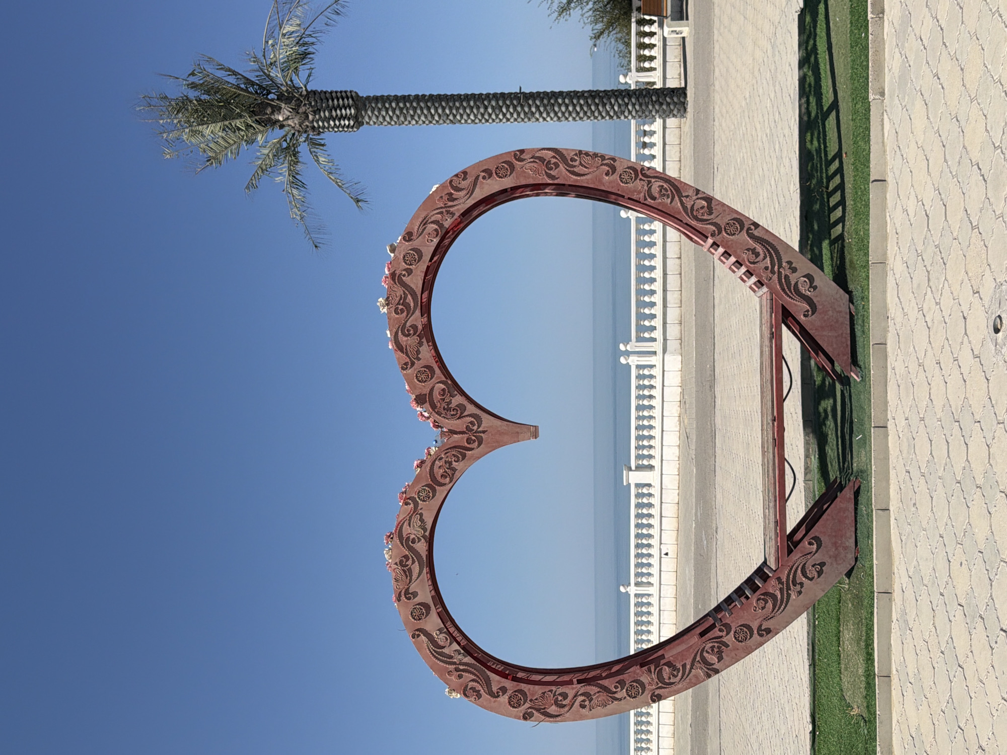 Aktau seafront contrasts: ornate promenade bench and rising unfinished tower
