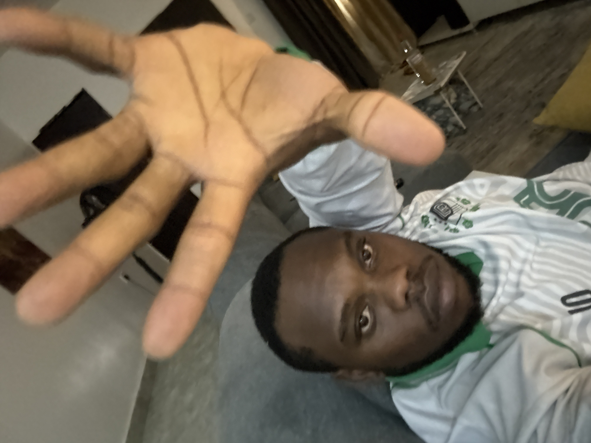 Man watches TV, rests on couch in Nigerian home