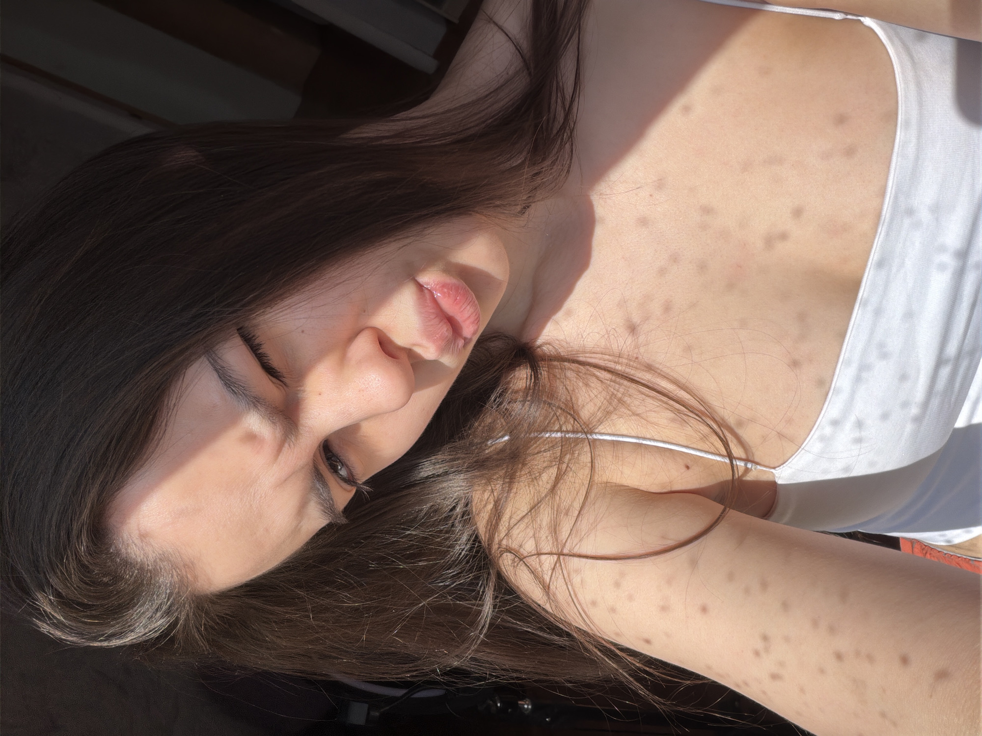 Woman takes selfies in sunlit room in Chaikovsky