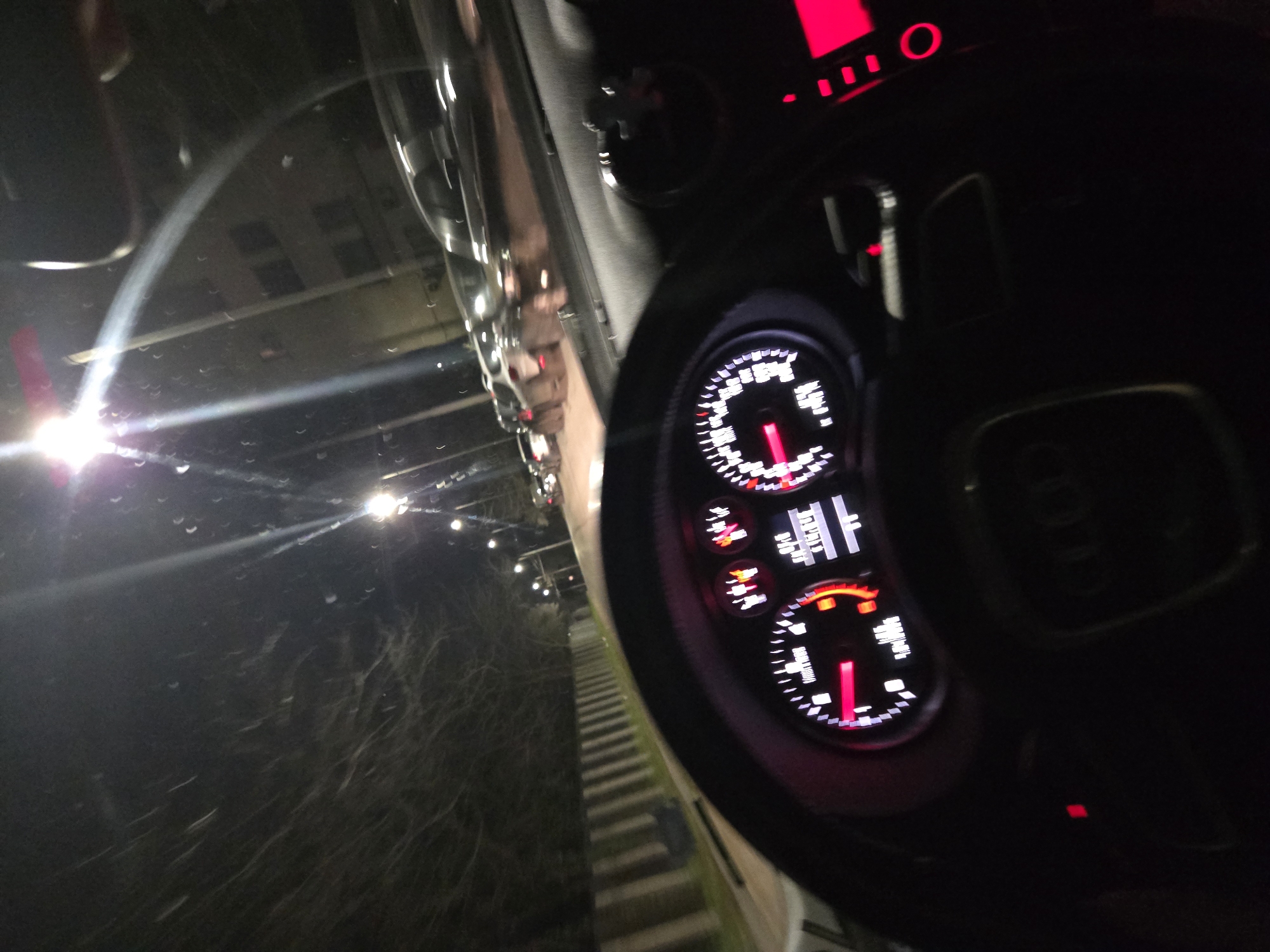 Nighttime Urban Driving Captured Through Audi Dashboard View