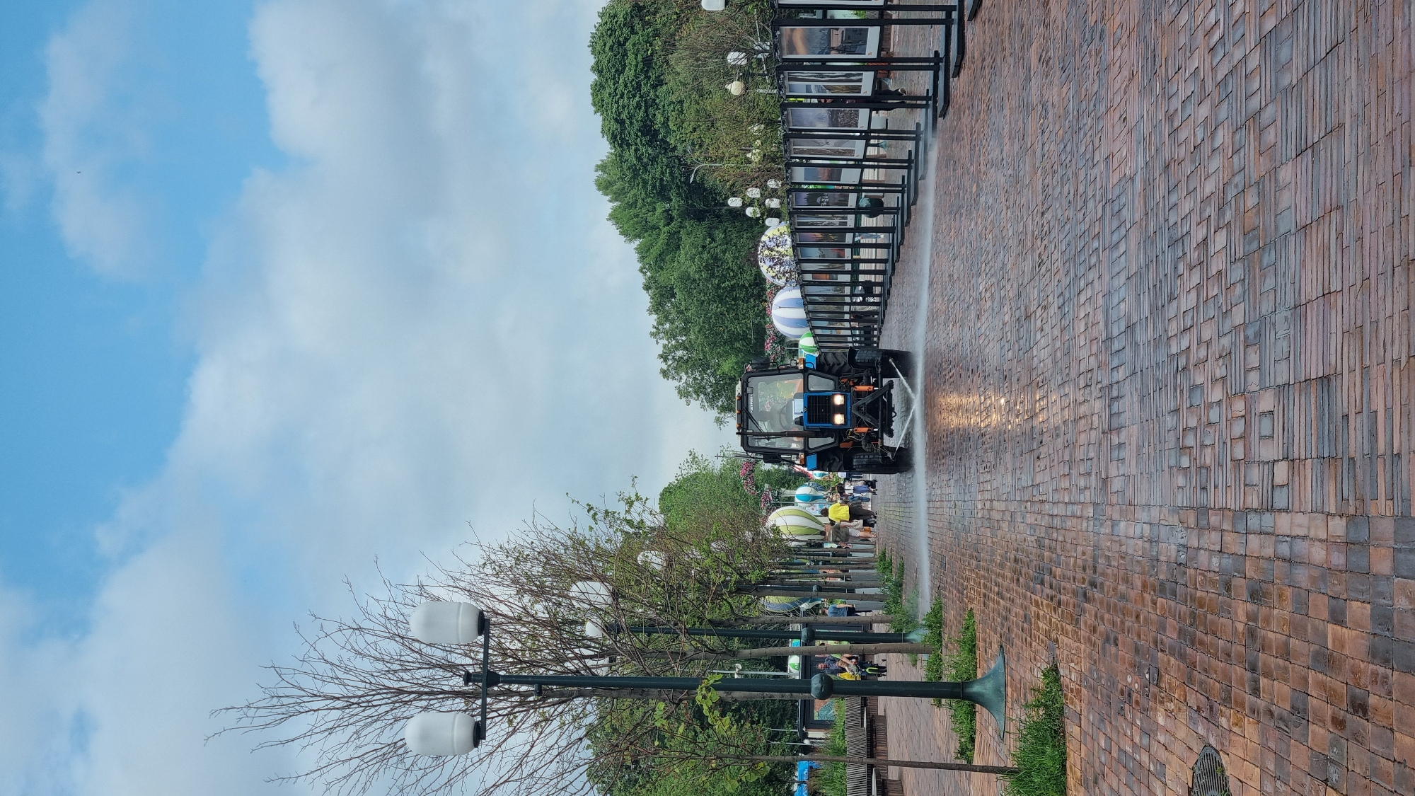 Moscow park morning: metro monument, wet brick paths, city backdrop