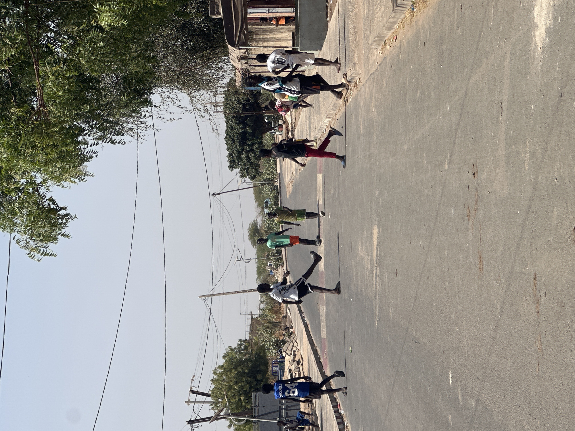 Children walk paved road in rural Senegal community