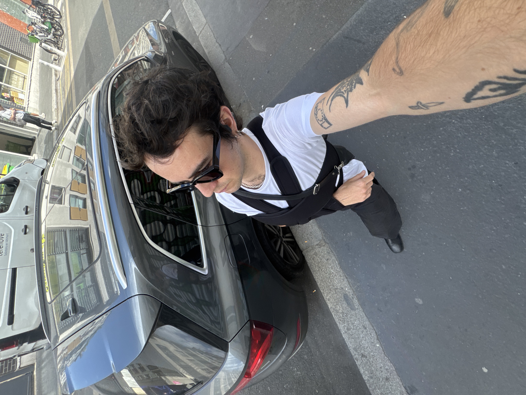 Man photographed beside car on Paris street
