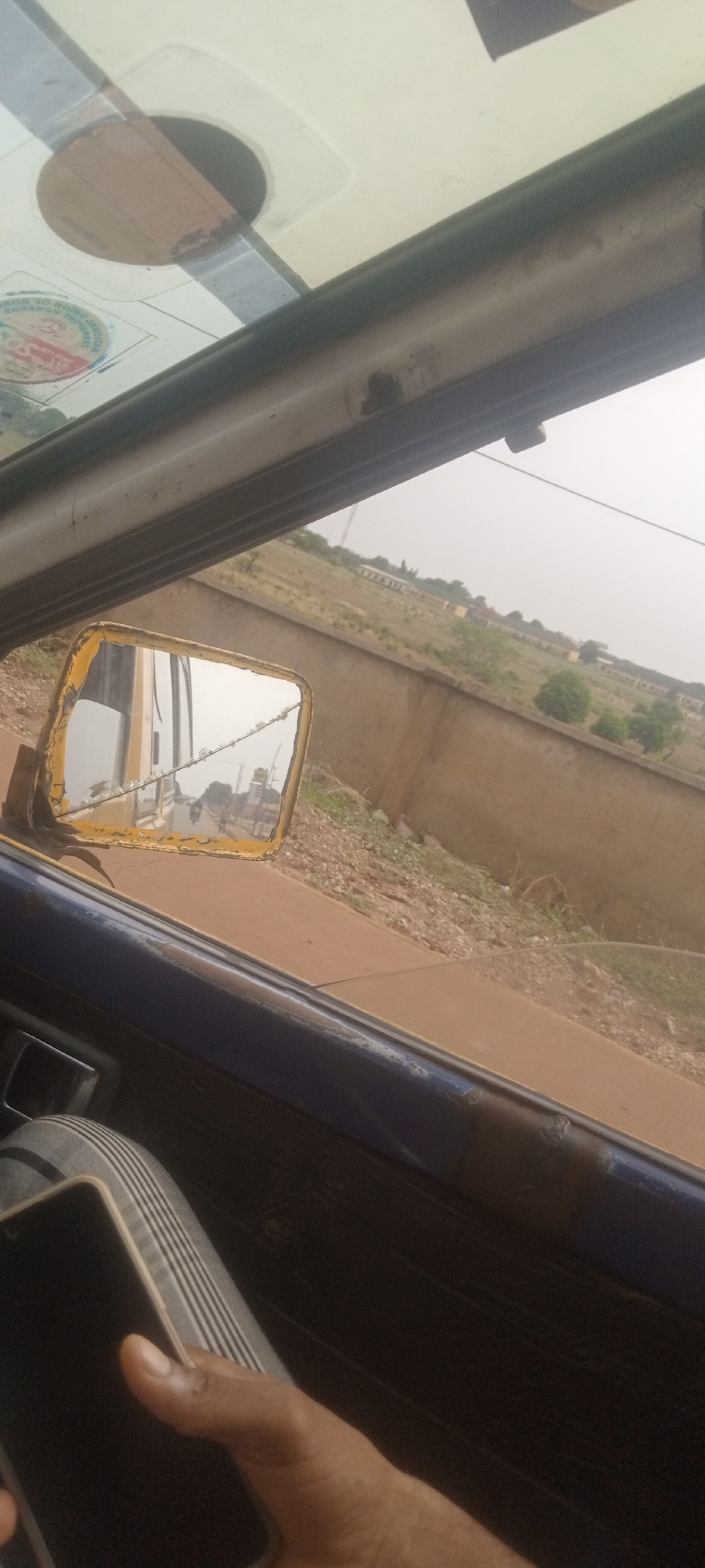Vehicle journey documented through dusty Nigerian streets