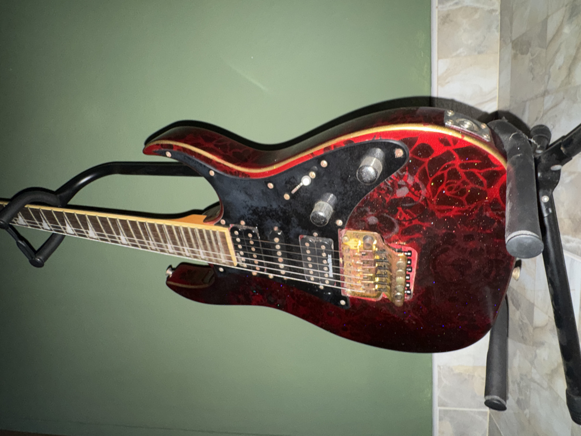 Red electric guitar on stand, Karon home interior