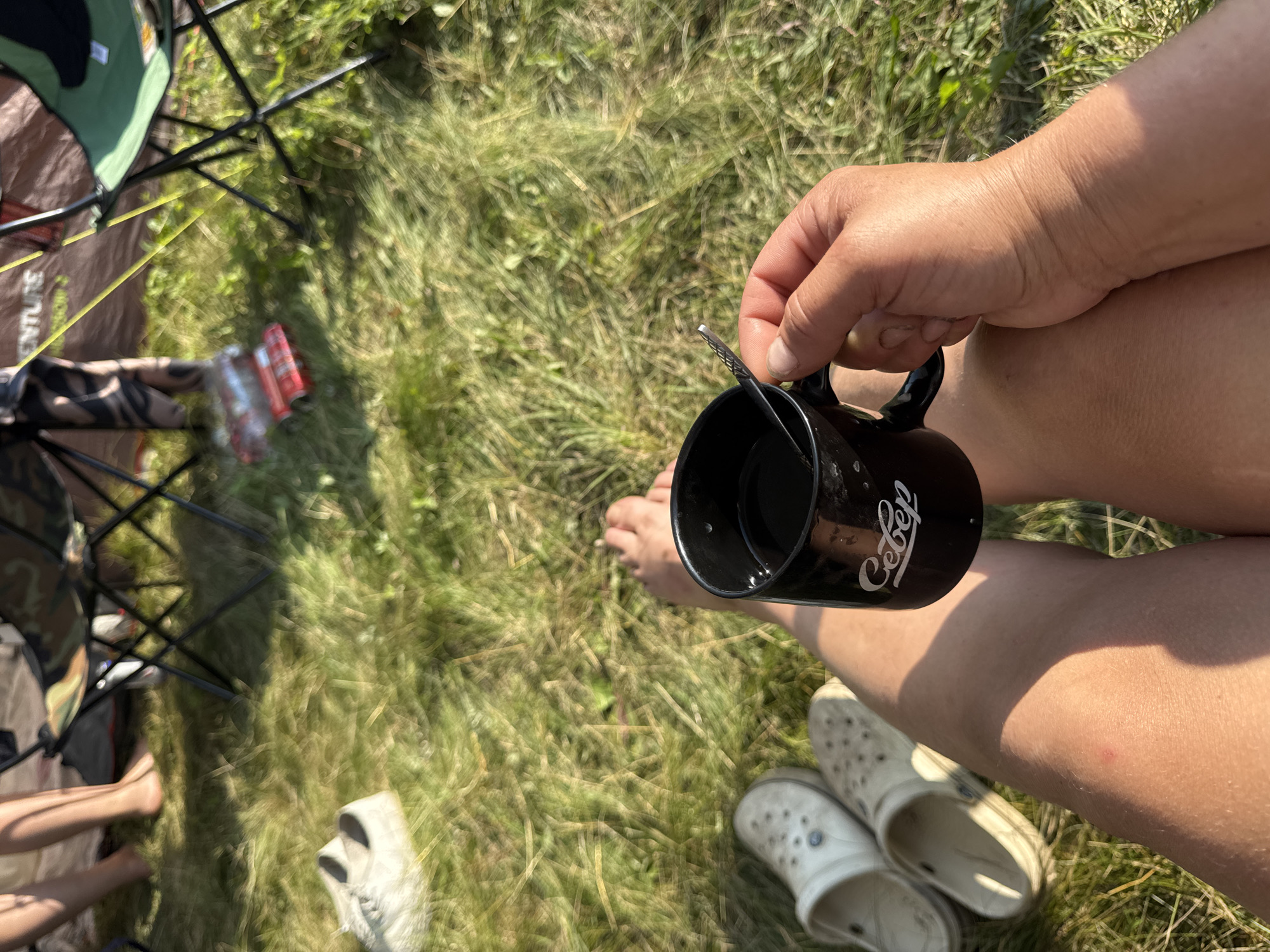 Sunny campsite morning with coffee, chairs, and tents