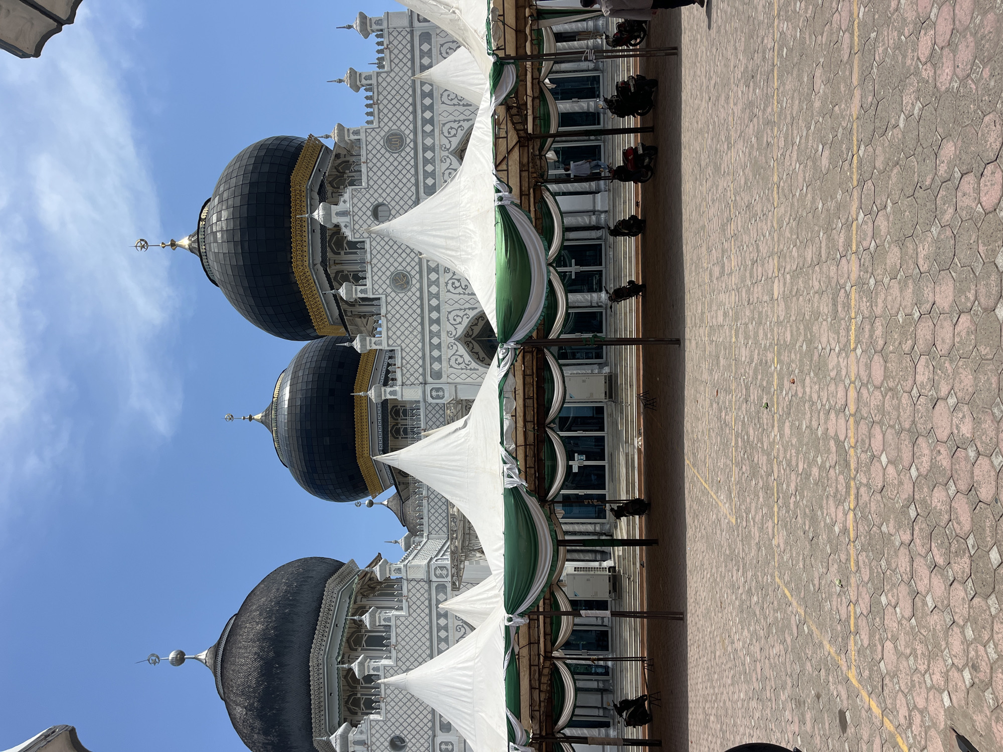 Visitor documents Indonesian mosque architecture and worshippers in morning visit