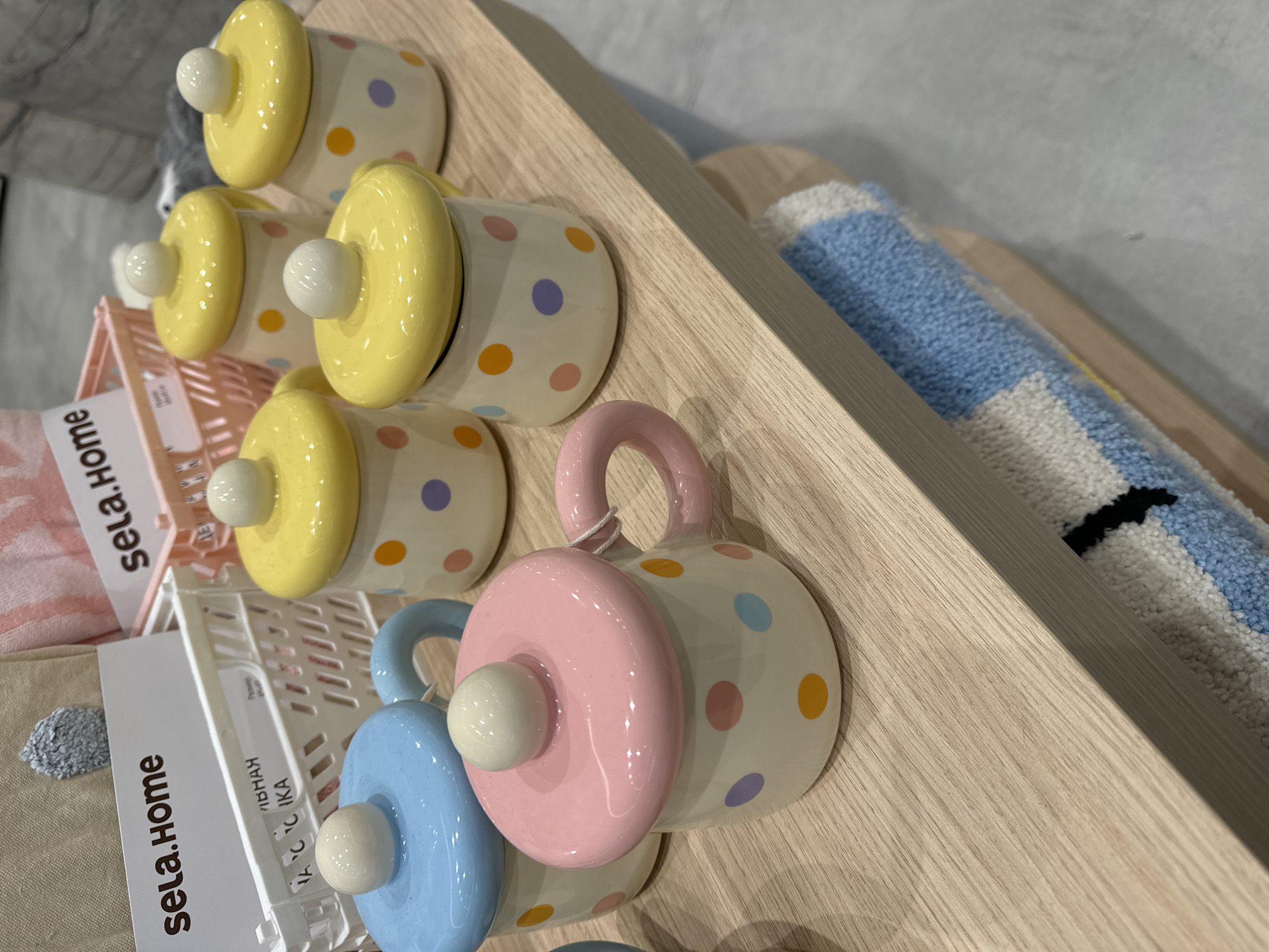 Pastel ceramic mugs displayed on retail shelf in Moscow