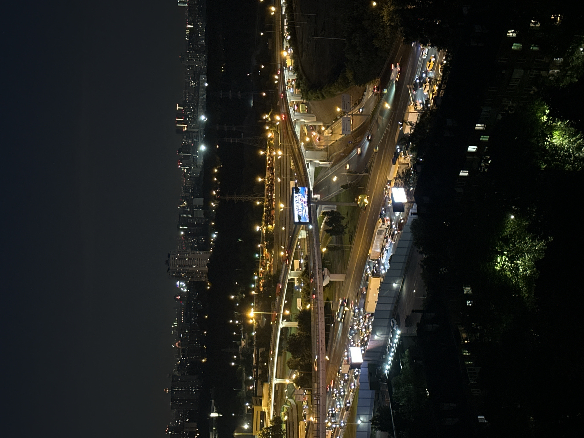 Orange moon rises over Khimki's glowing highway interchange at night