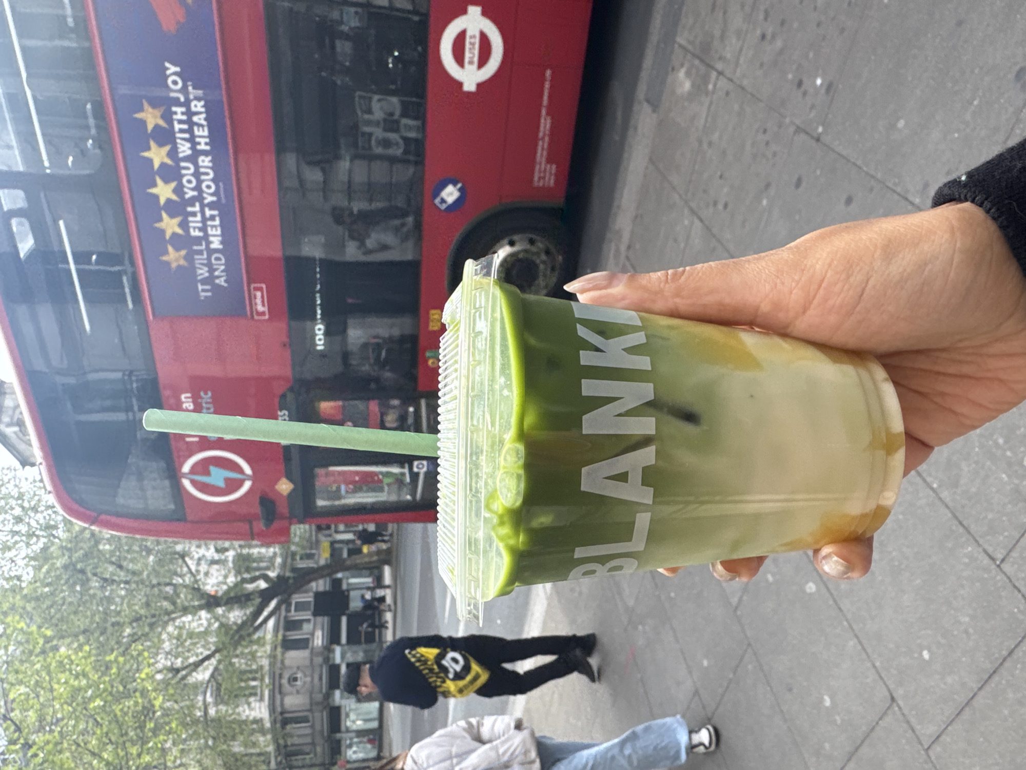Green tea drink photographed against London double-decker bus backdrop