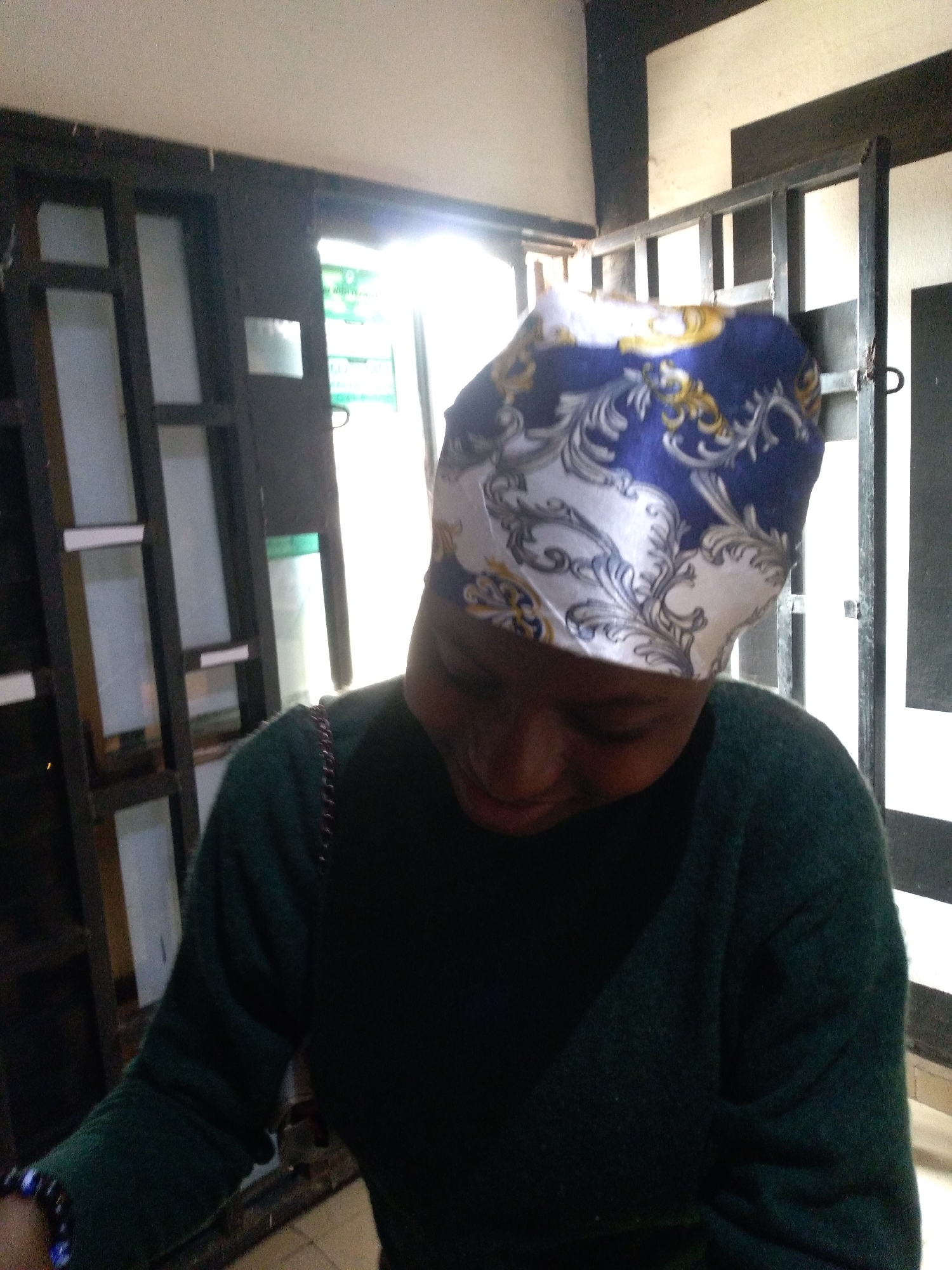 Person in headwrap observed indoors using phone over six minutes