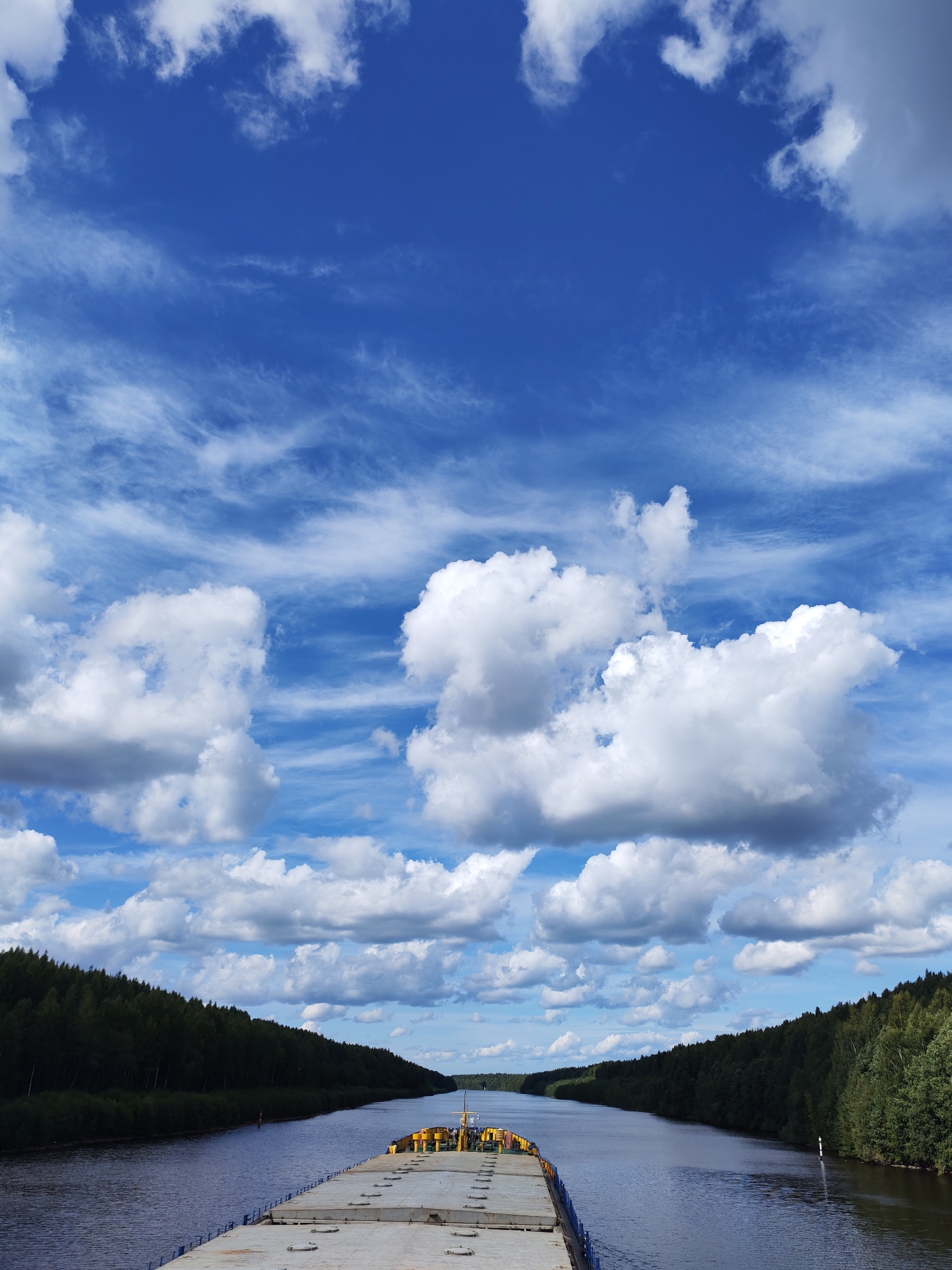 Barge on a calm Siberian river, forested banks in view