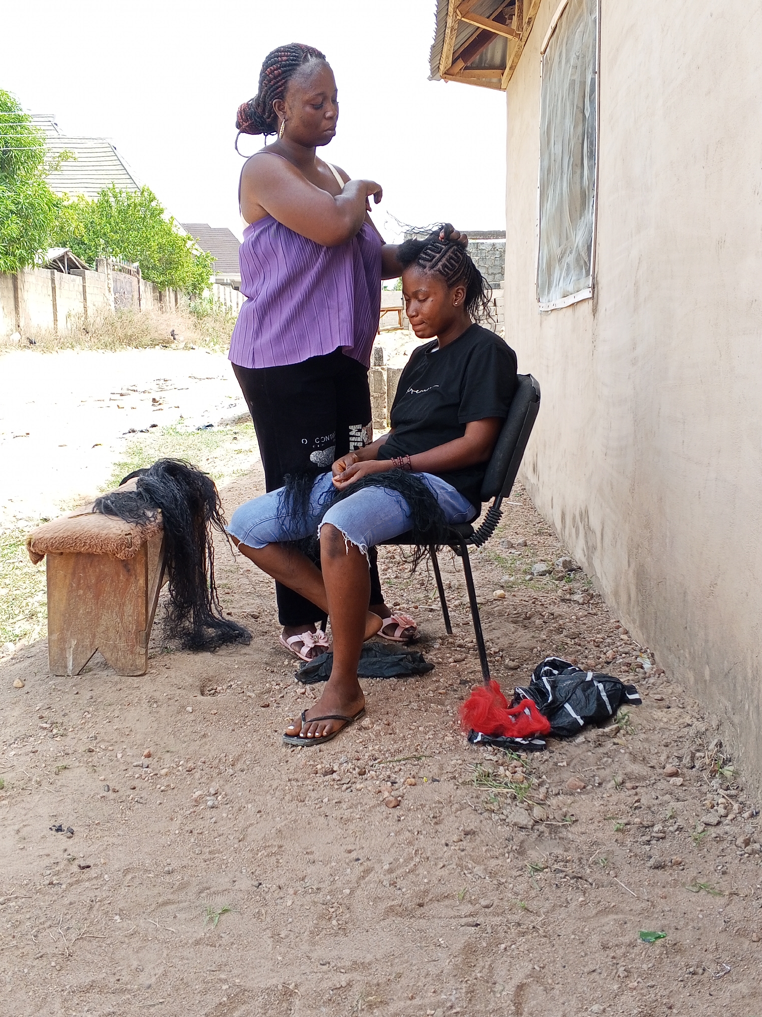Women hair braiding session documented in Adonkolo, Nigeria