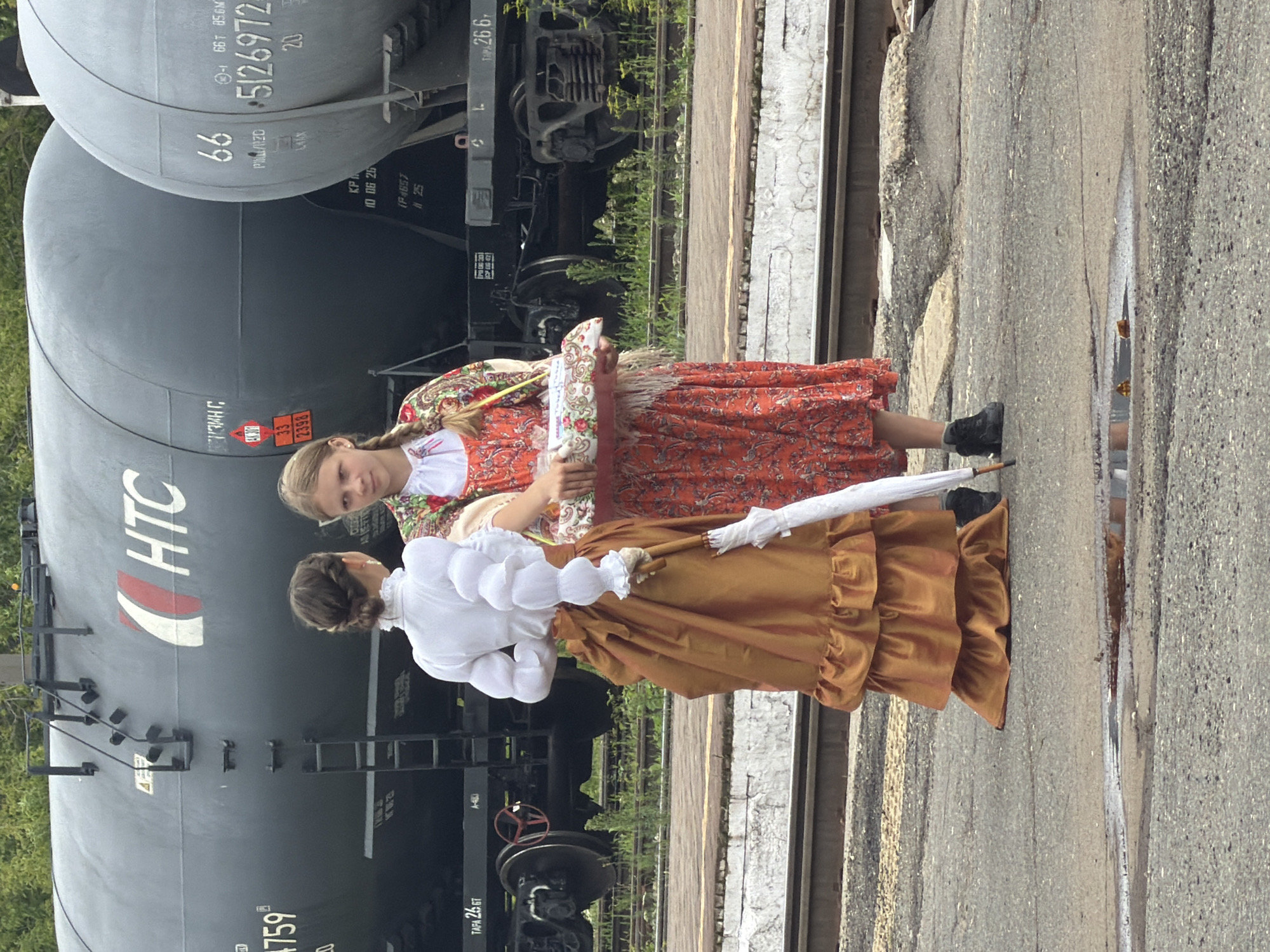 Period-dressed gathering at Sarapul railway yard around vintage steam locomotive