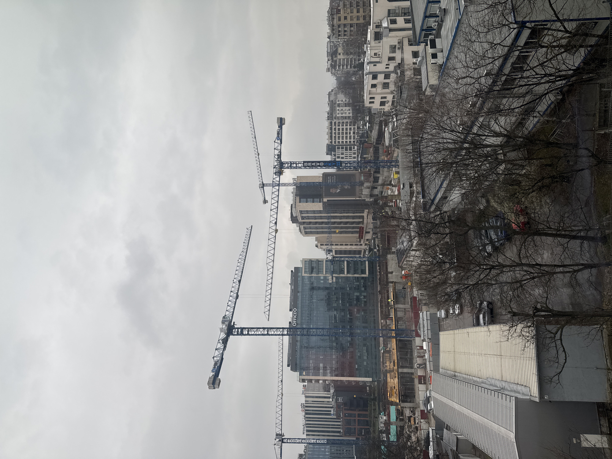 Construction cranes dominate Sofia skyline under overcast skies