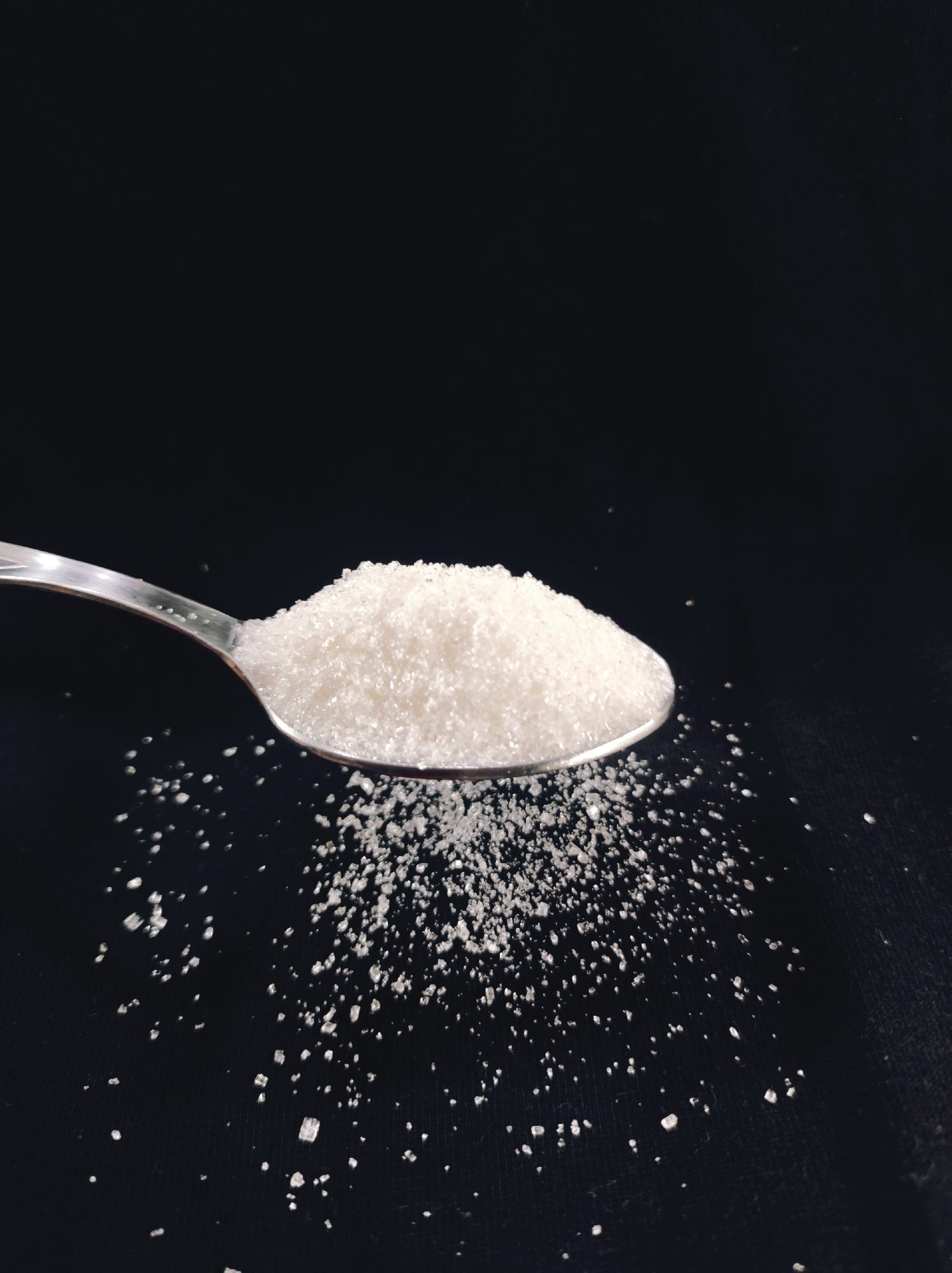 Sugar arranged into spoon shots and a smiley heart on black