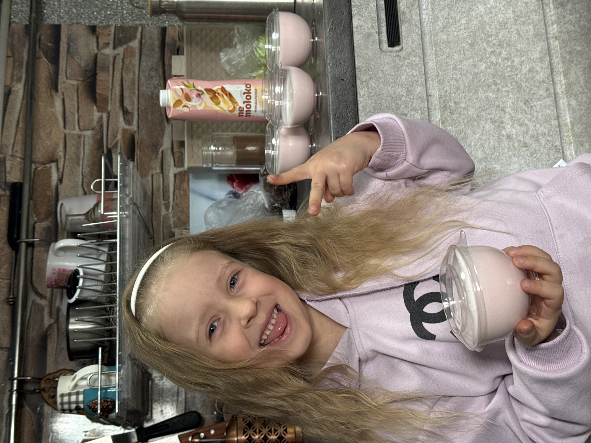 Girl enjoys pink desserts in Russian kitchen
