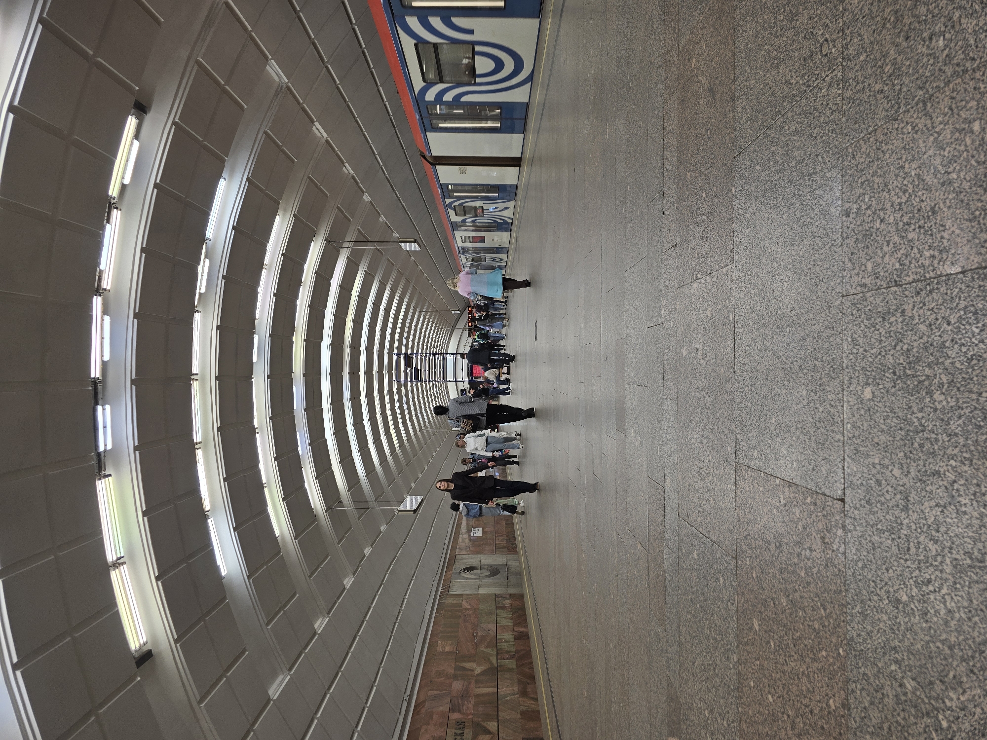 Subway train arrives at station platform displaying Cyrillic destination