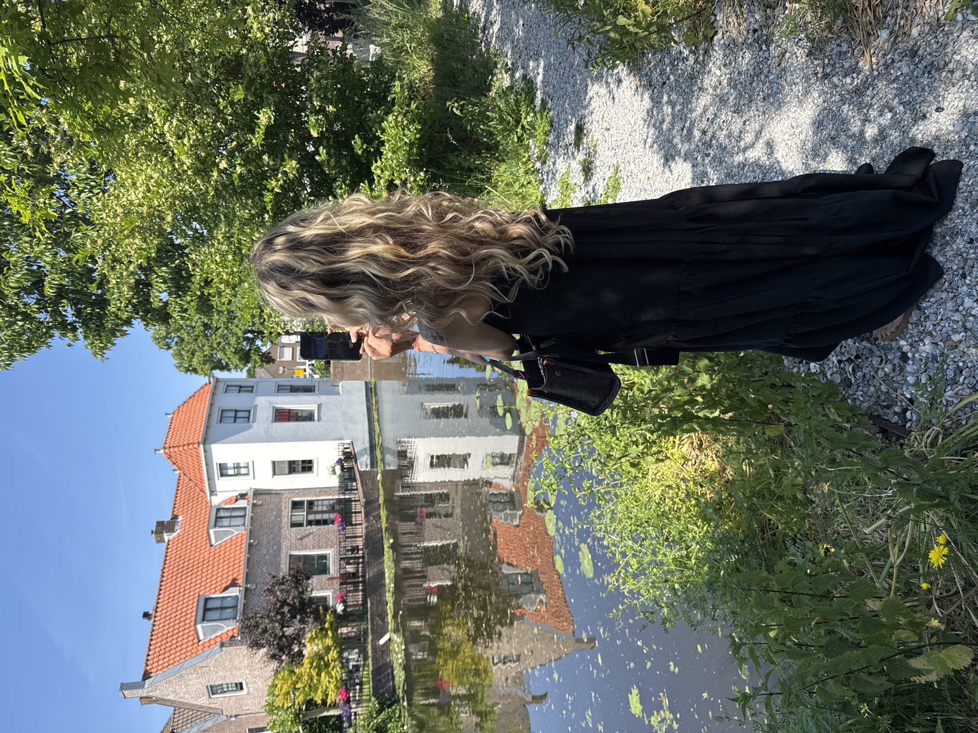 Tourist photographs scenic canals in Dutch coastal town