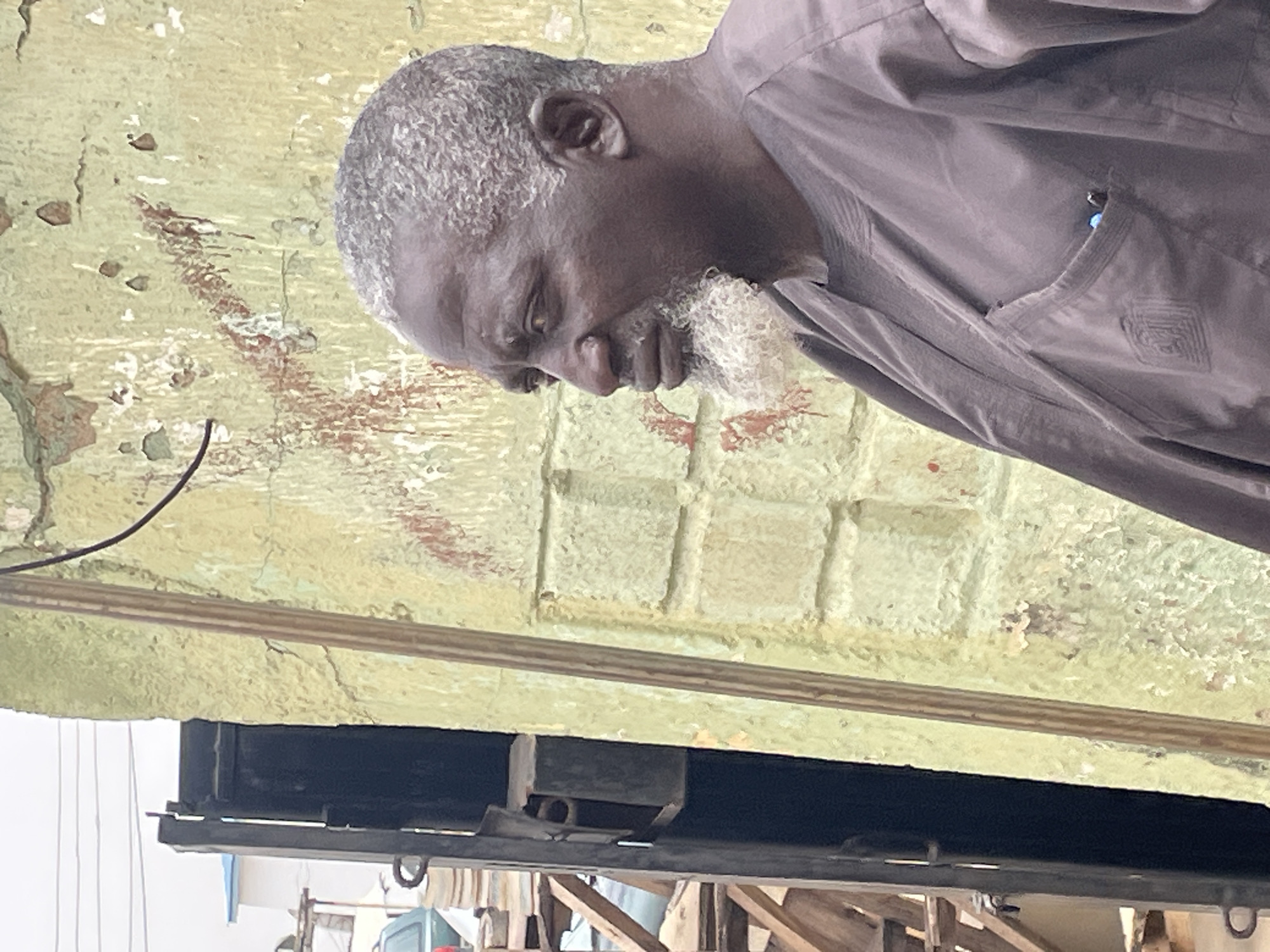 Everyday moments captured in Jos: elderly man, water tower