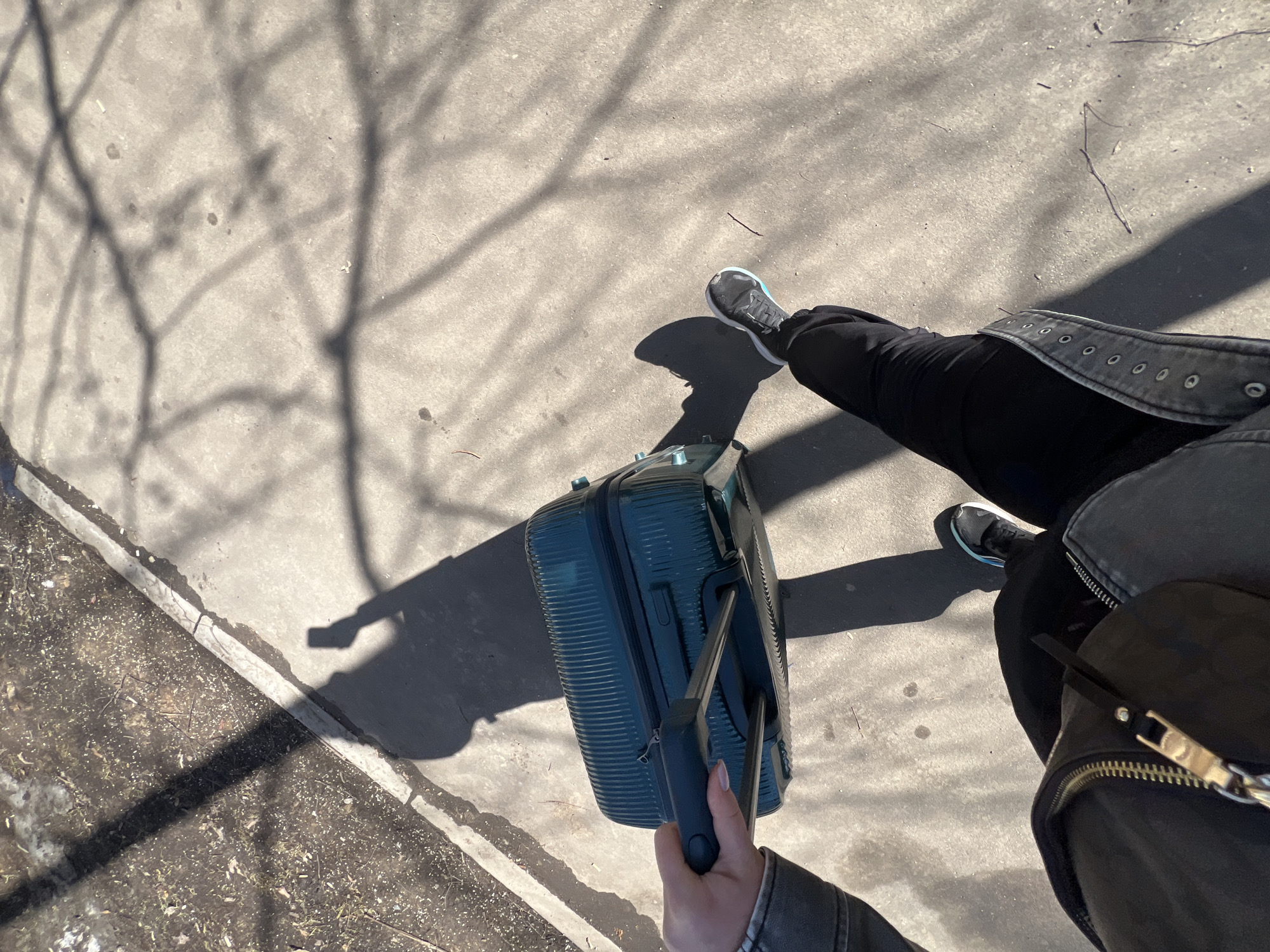 Traveler with suitcase navigates snowy Moscow sidewalk