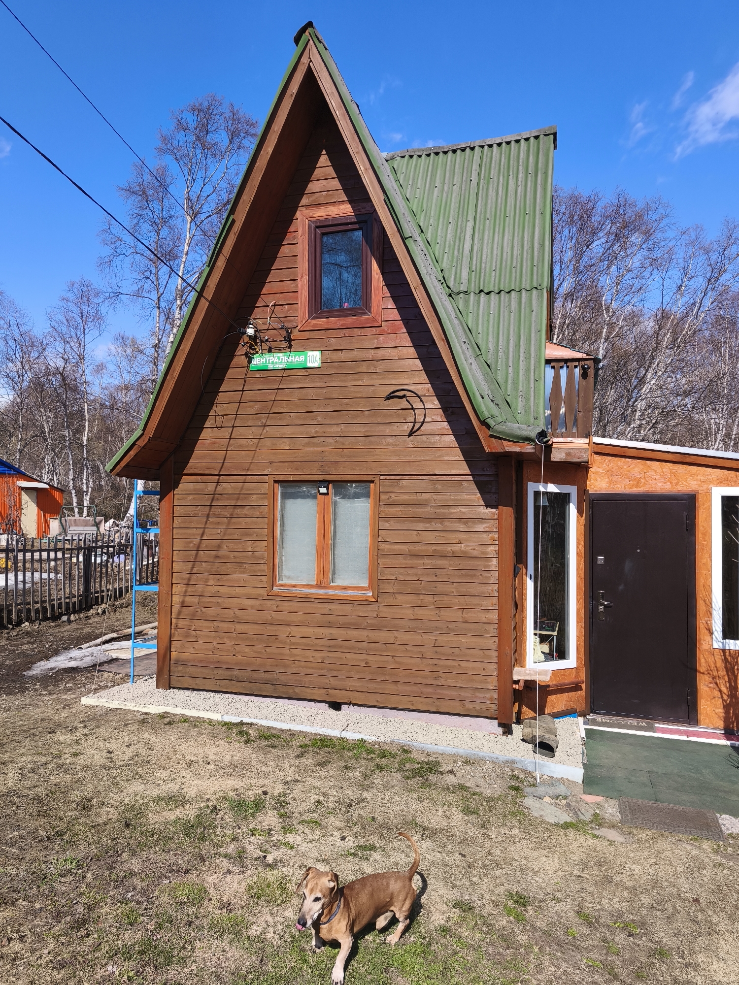 Brown wooden house with Cyrillic address sign documented
