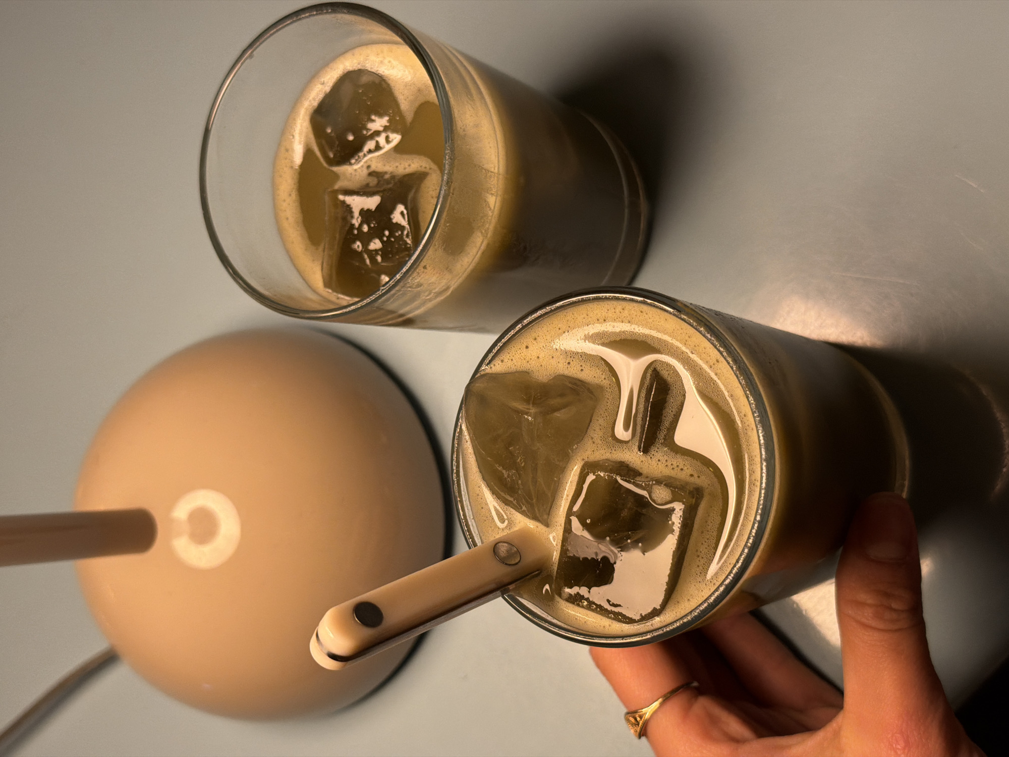 Person enjoys iced beverages in Krasnoyarsk cafe setting