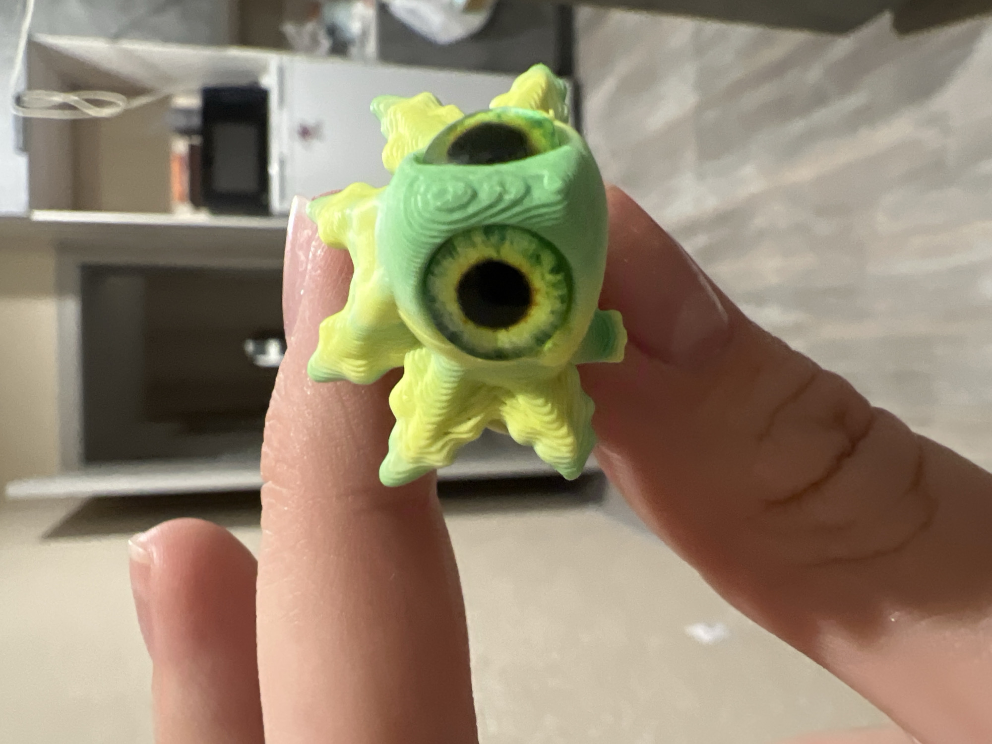 Person displays 3D-printed creature figurine in Krasnoyarsk kitchen