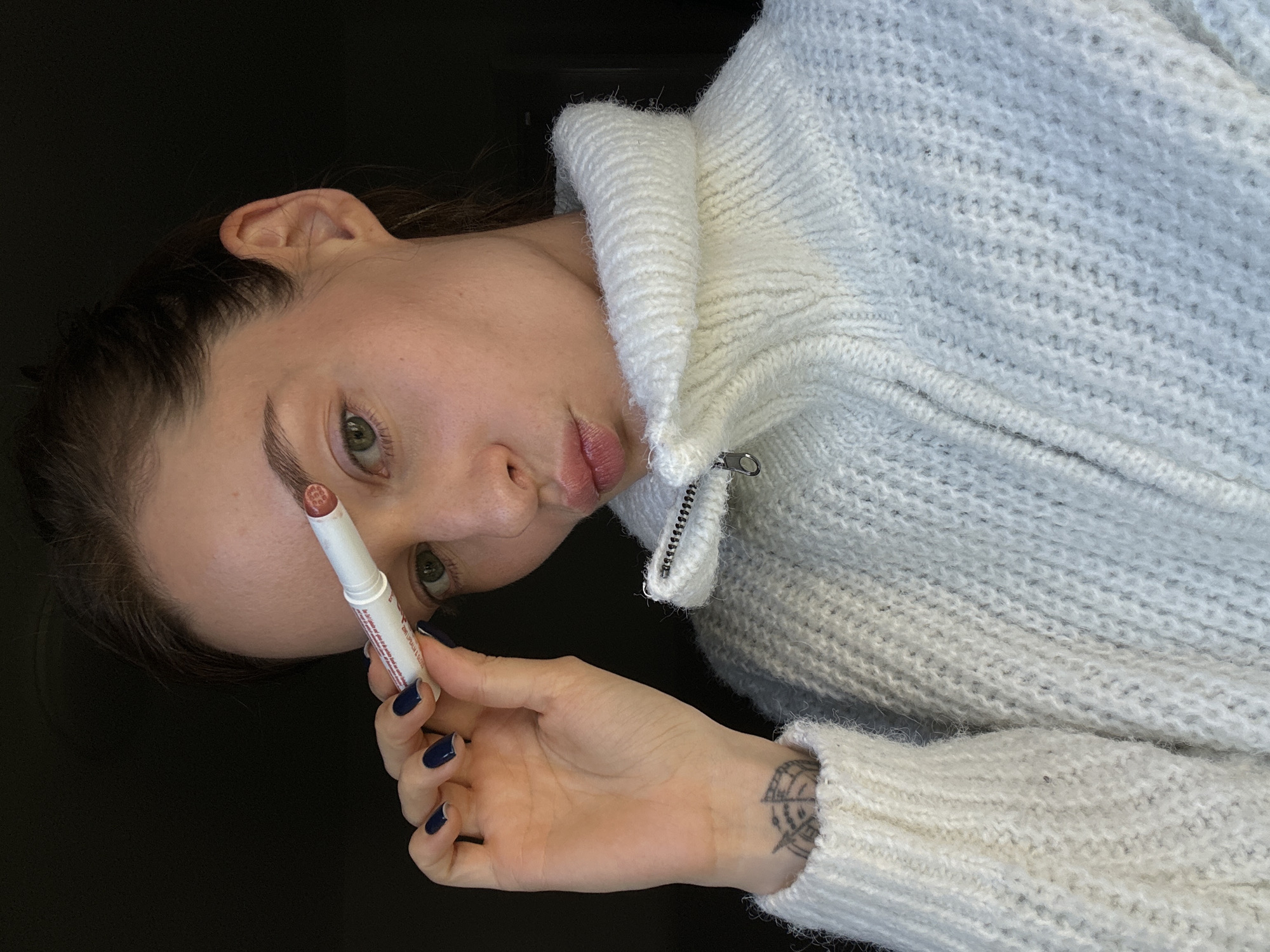 Woman applies lip balm in Kiel, Germany
