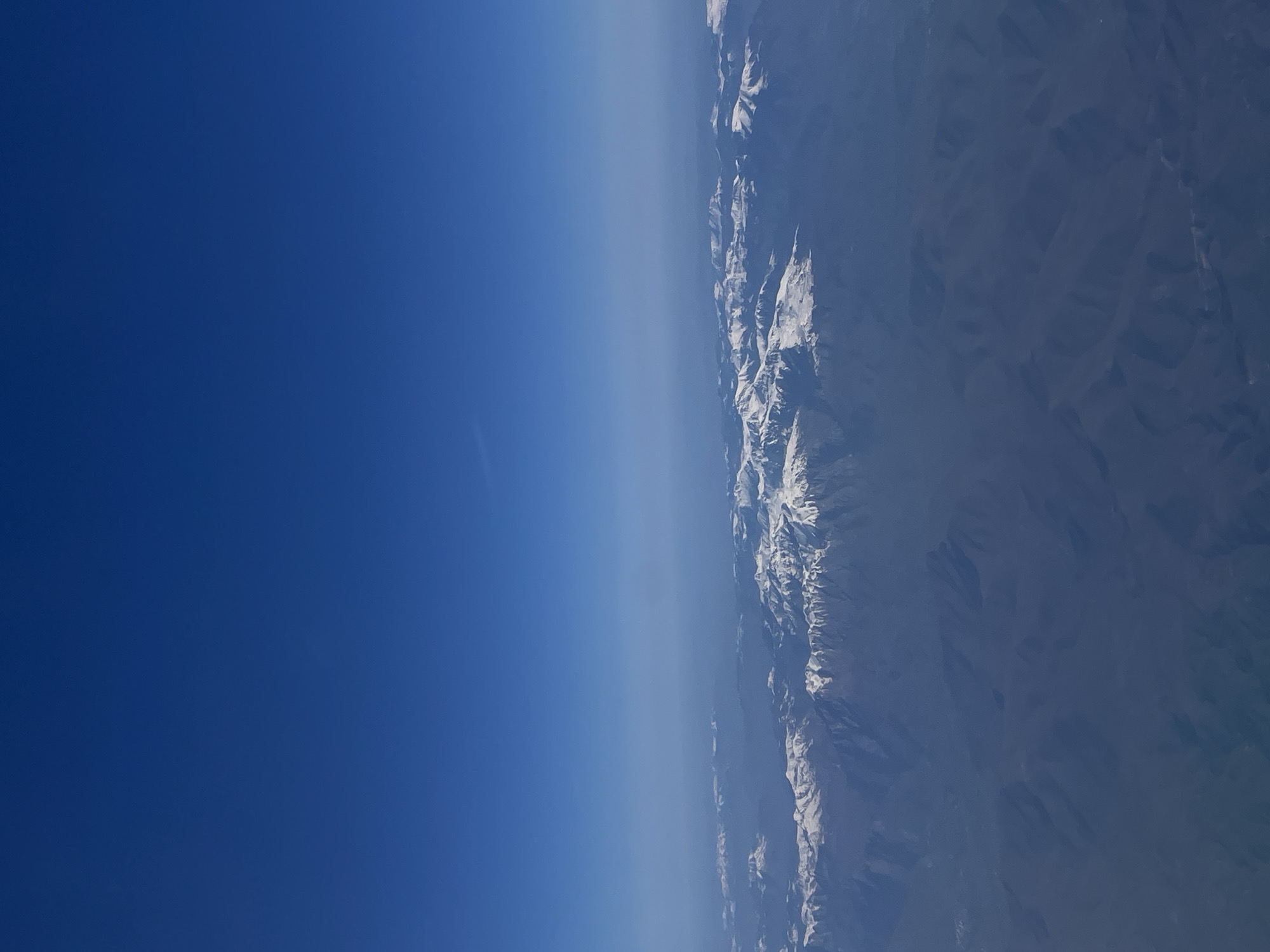 Aerial view captures snow-covered Albanian mountains from airplane