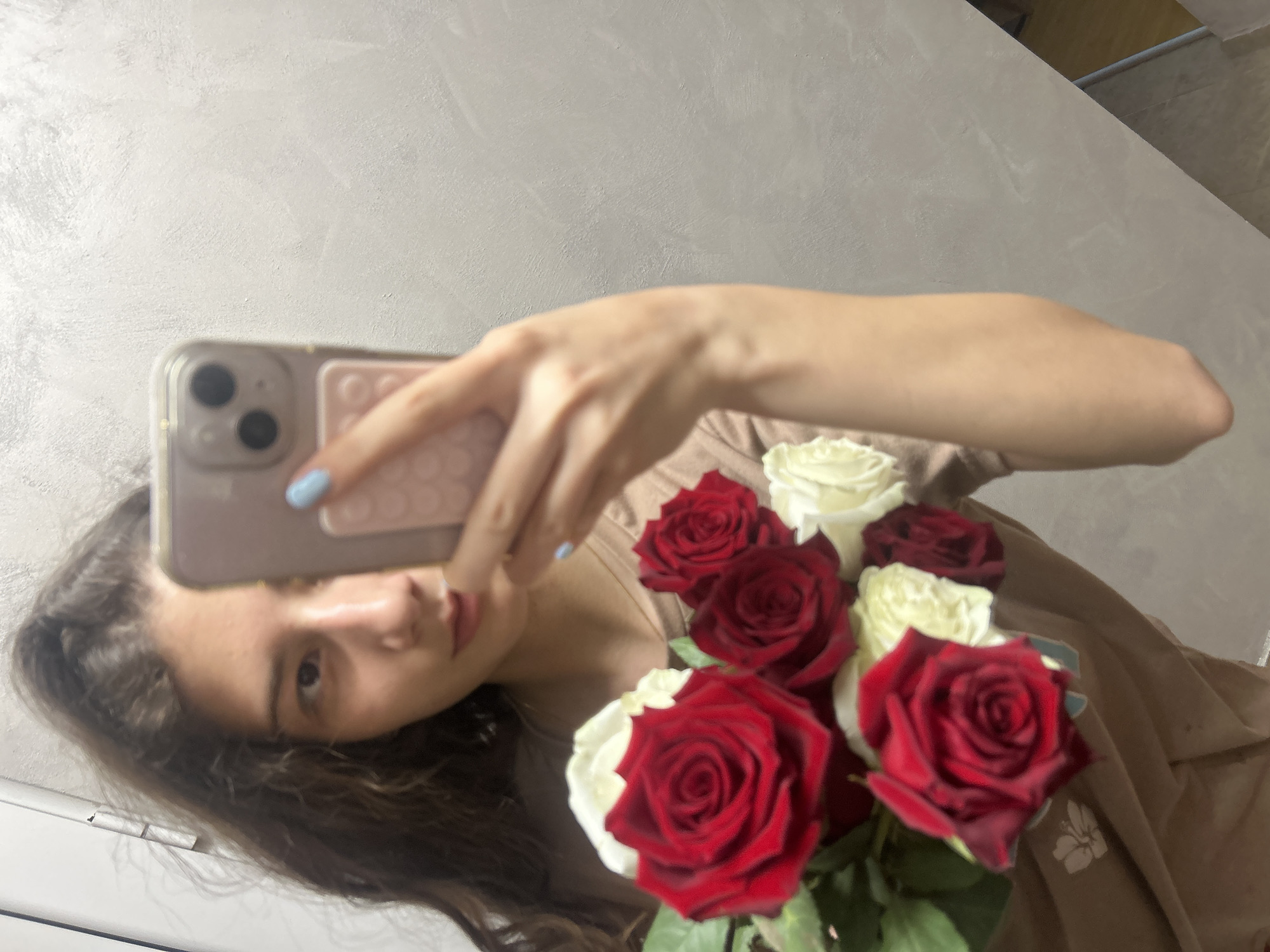 Woman photographs herself with roses, cat photobombs session