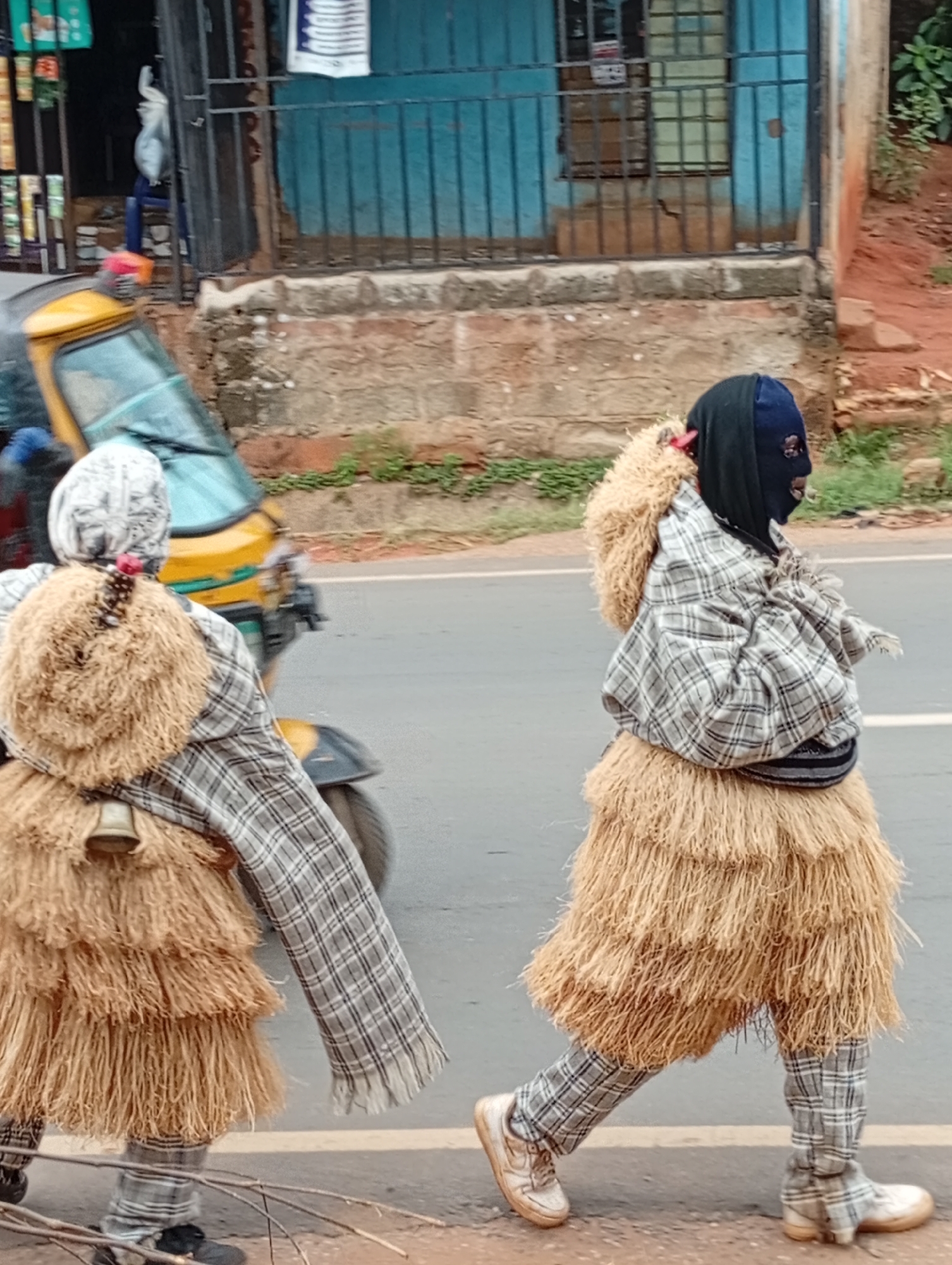 Traditional masquerades walk alongside children on Nkpor road