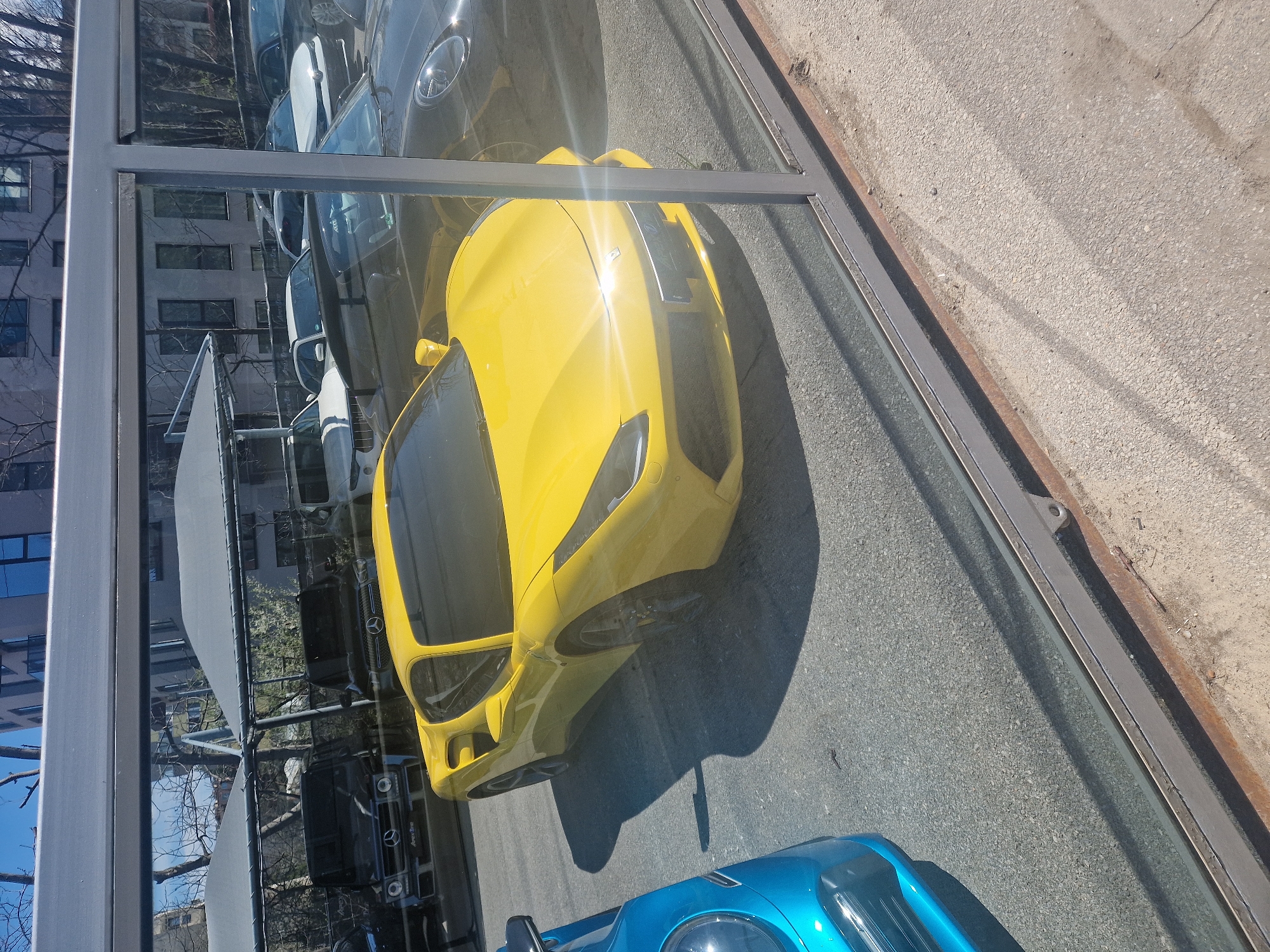 Yellow sports car spotted among parked vehicles on street