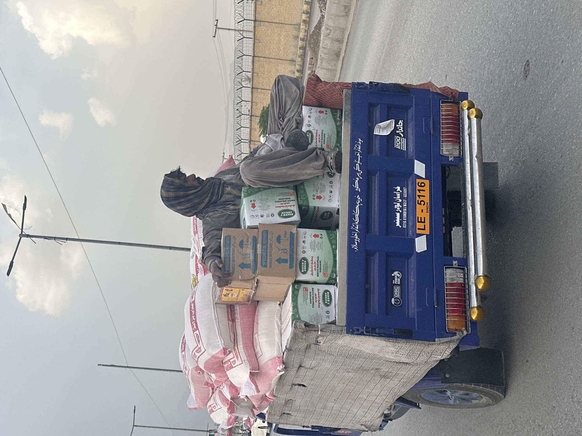 Man rides atop loaded vehicle in Quetta street