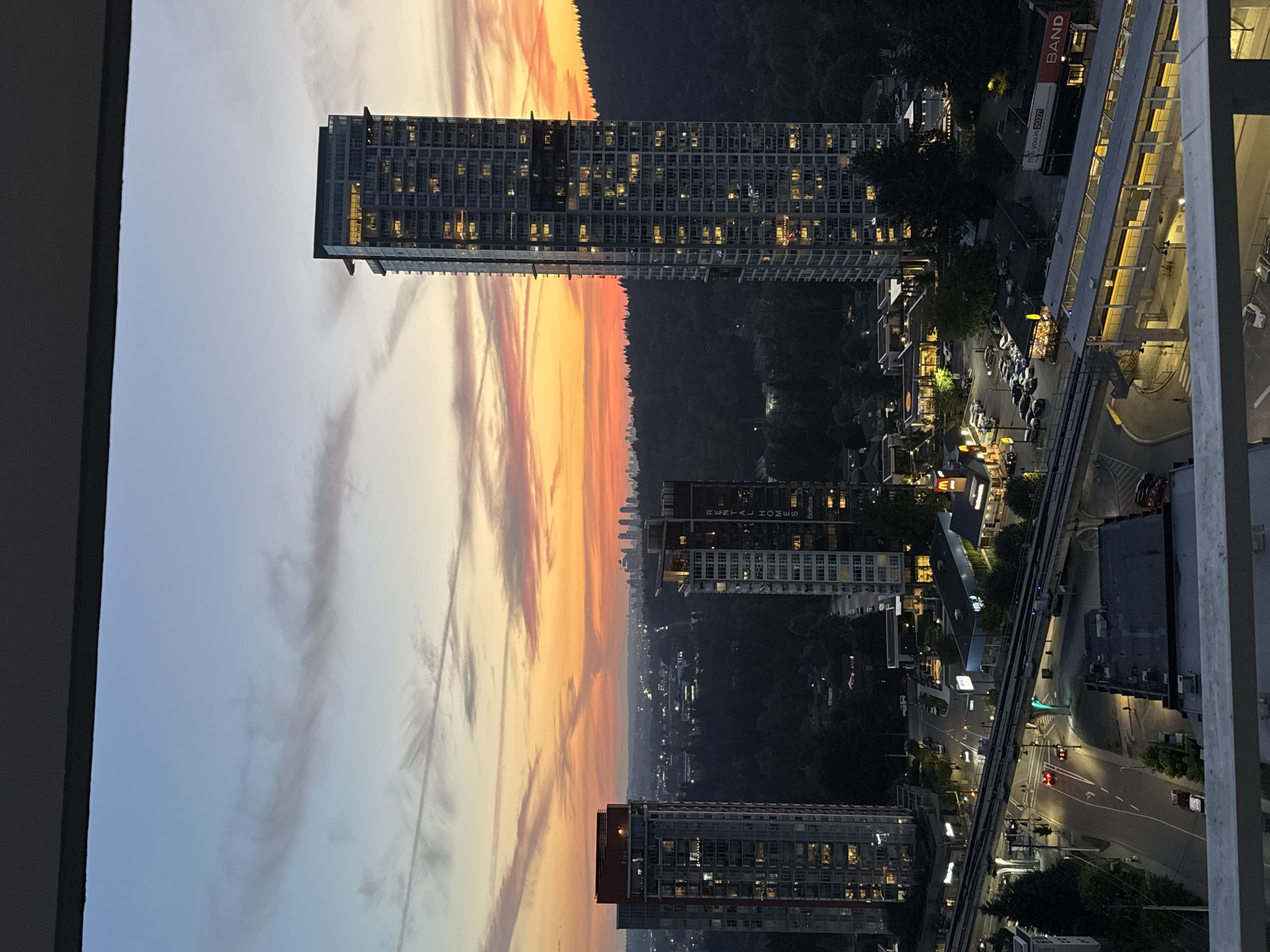 City skyline at dusk, vivid sunset colors over urban rooftops.