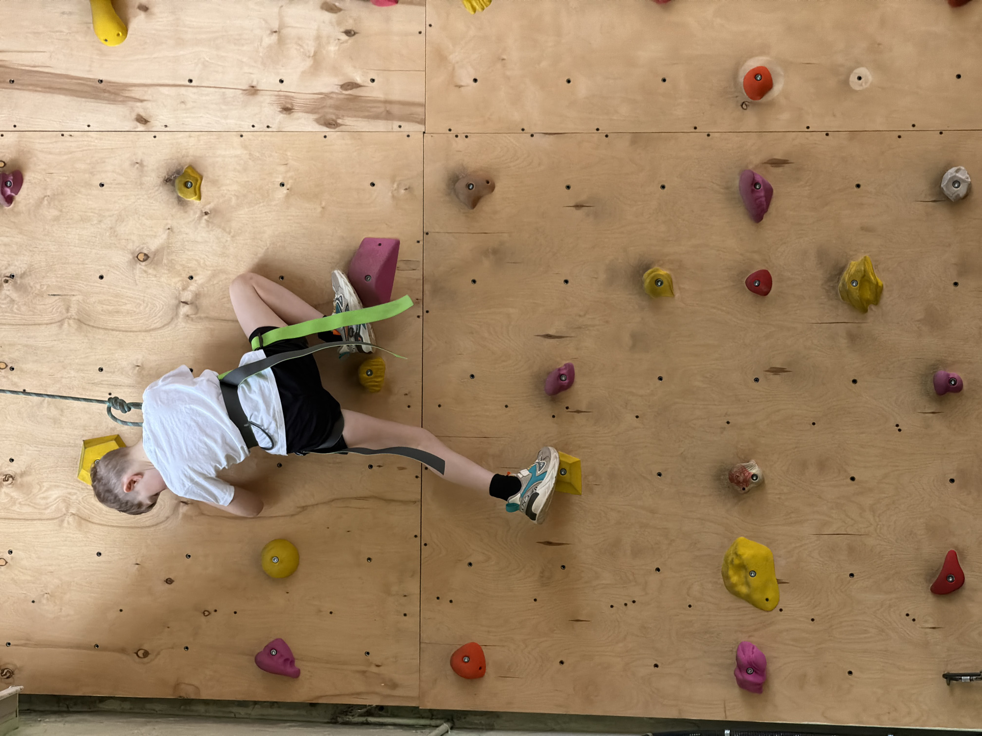 Boy rock climbs at indoor facility in Izhevsk, Russia