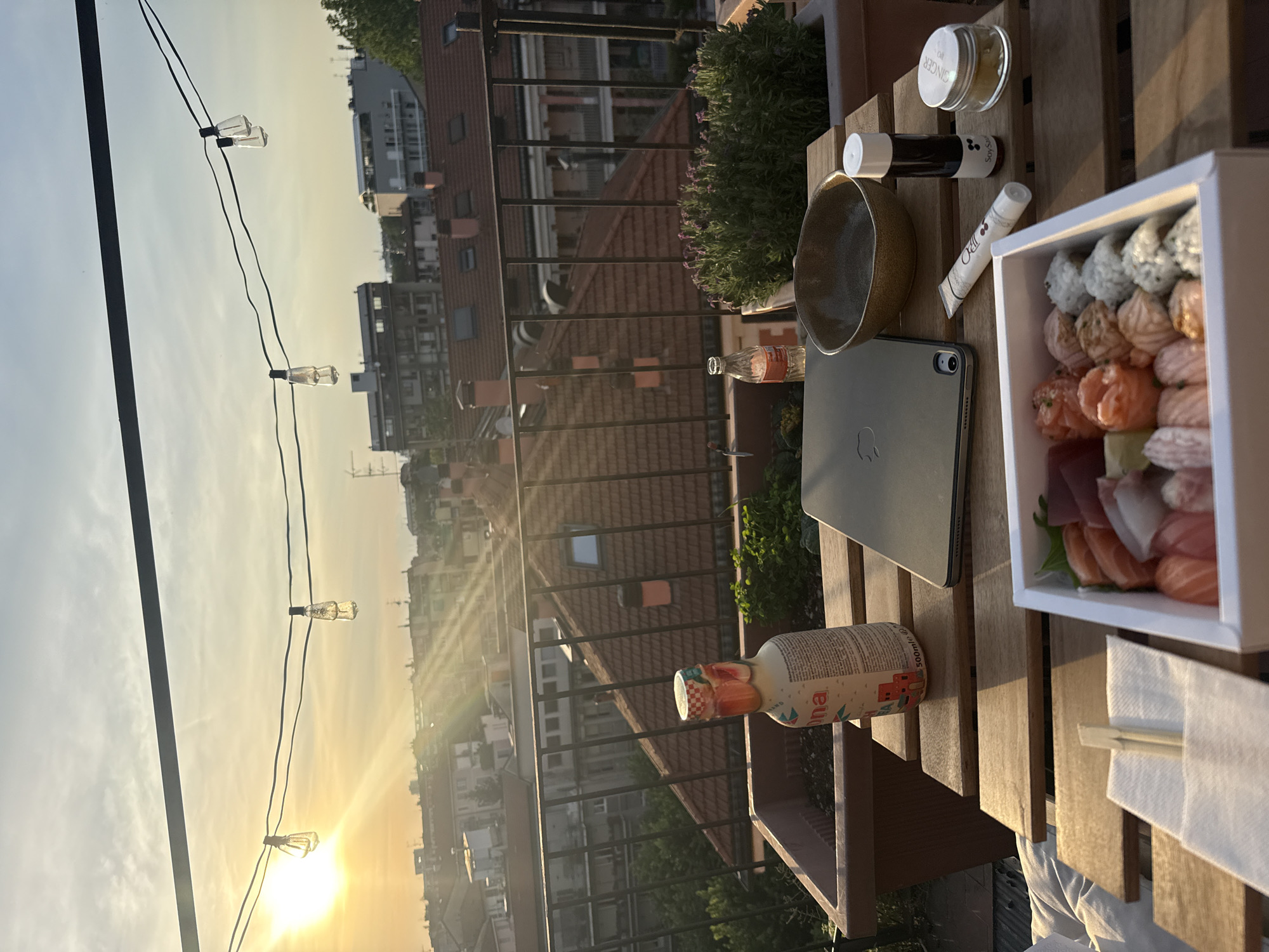 Sunset dinner setting captured on Milan balcony overlooking cityscape